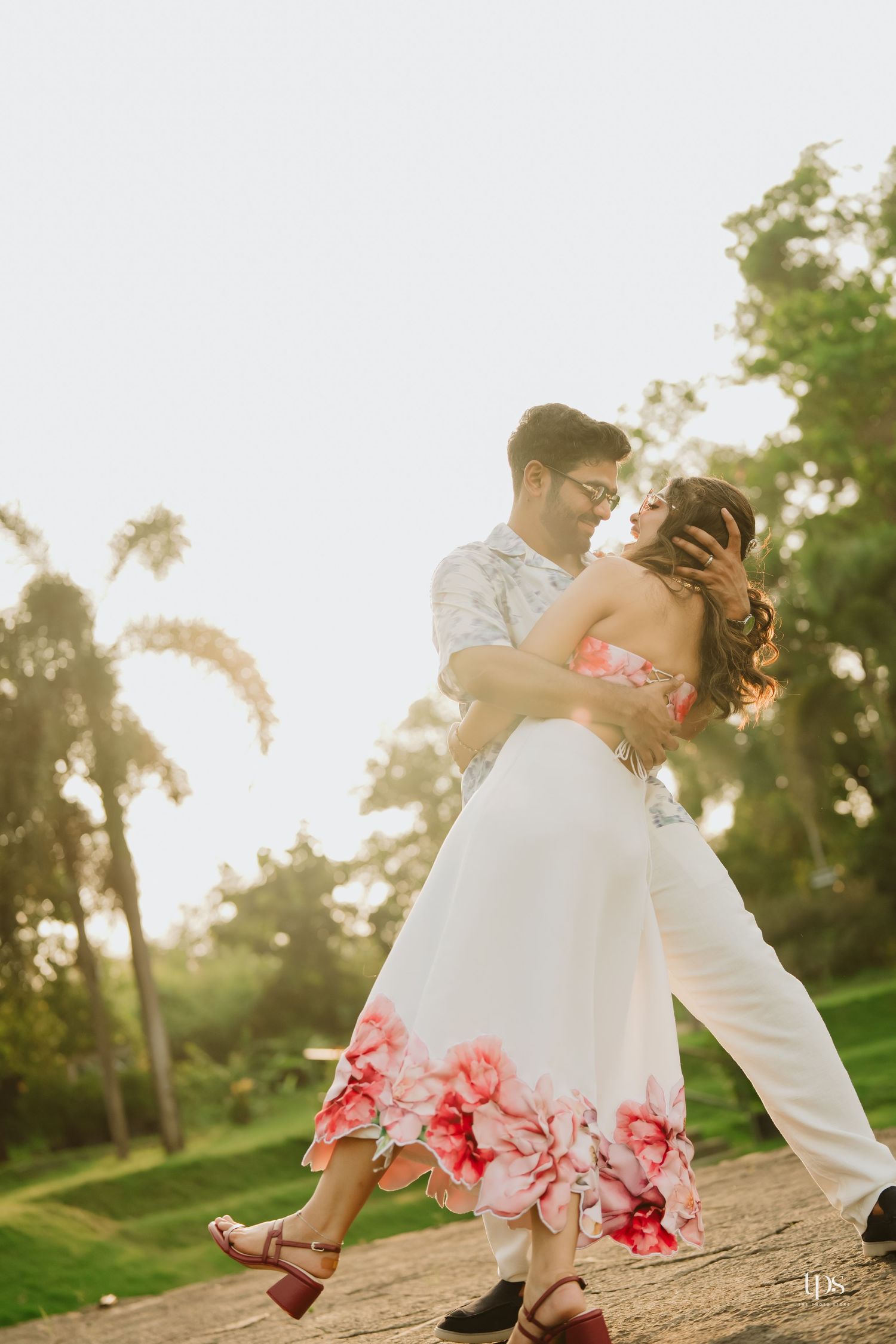 A romantic dance pose captured during a sunset photoshoot by the water.