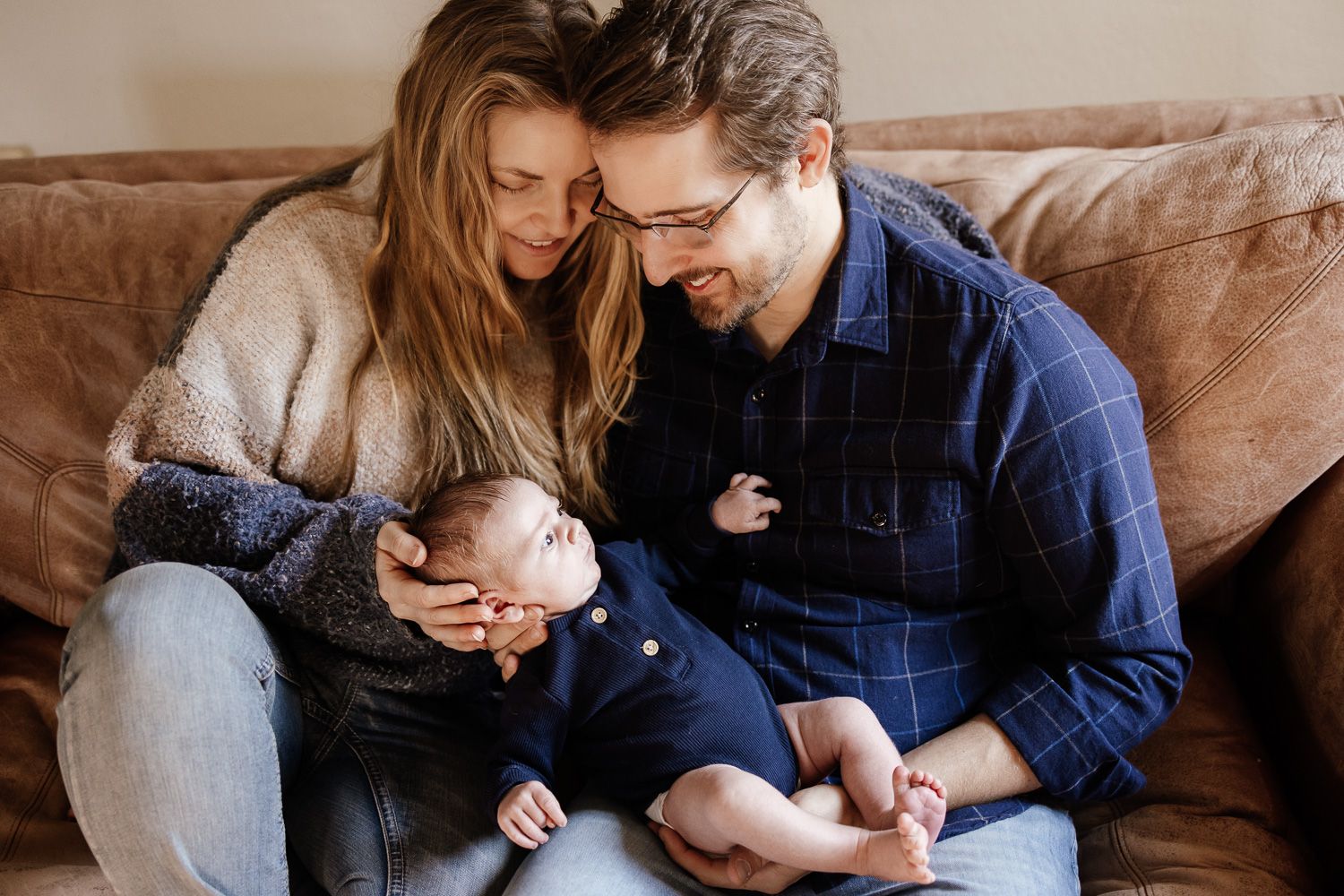 Parents cuddle their new baby at in-home lifestyle newborn photoshoot in San Jose