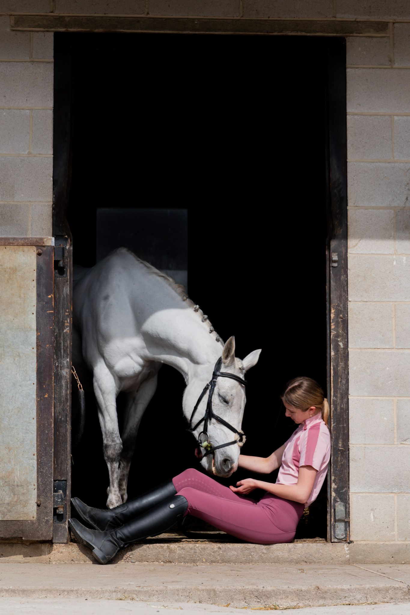 Beautiful equine portrait photograph of rider and horse in a stable. Photographer is Isobel Hughes Photography in Haworth West Yorkshire.