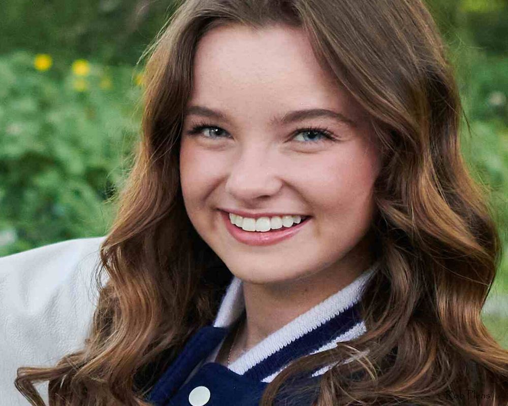 Closeup of high school senior sitting on bench at Decoursey Pond in Puyallup, WA