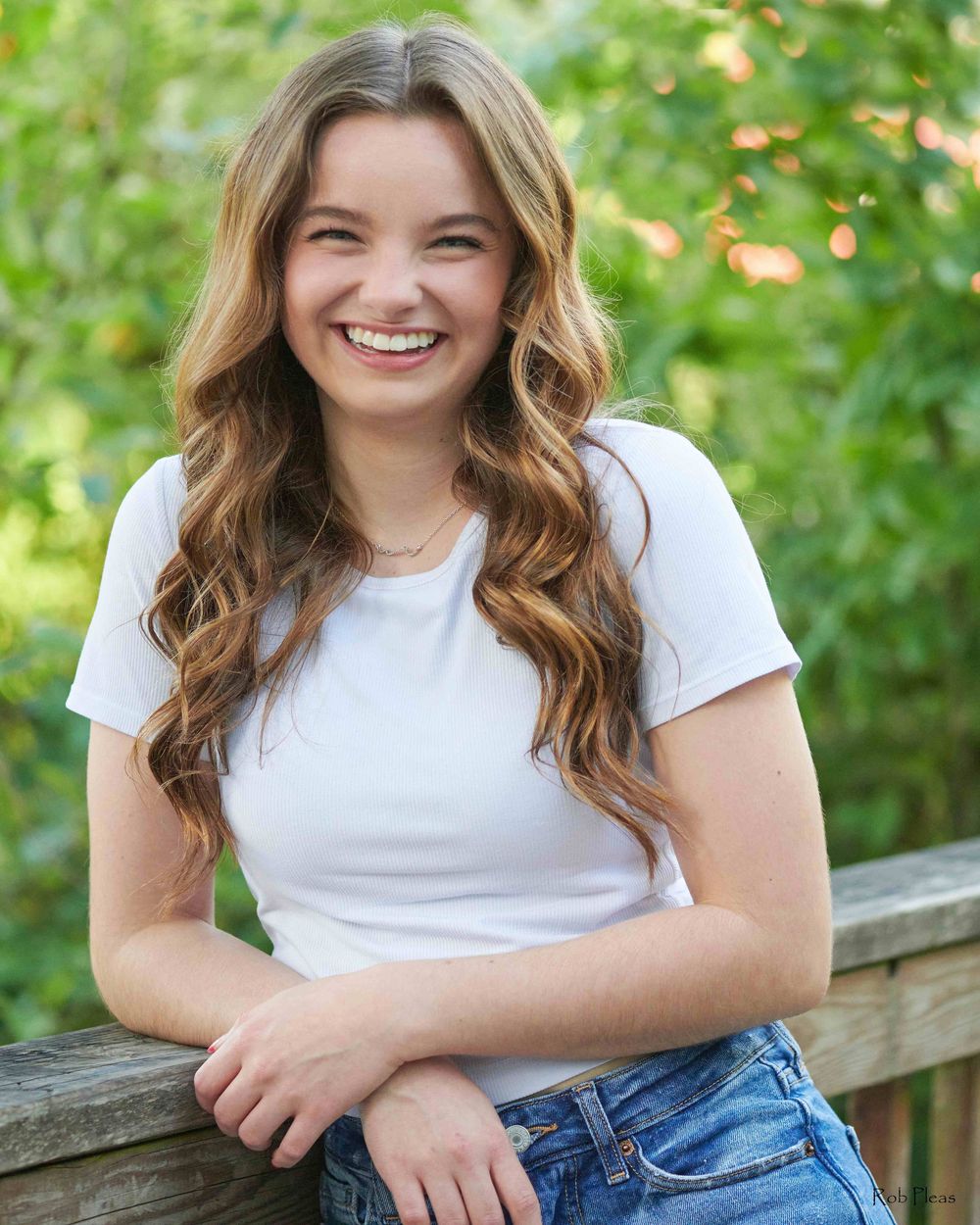 High school senior leaning on wooden bridge railing at Decoursey Pond in Puyallup, WA