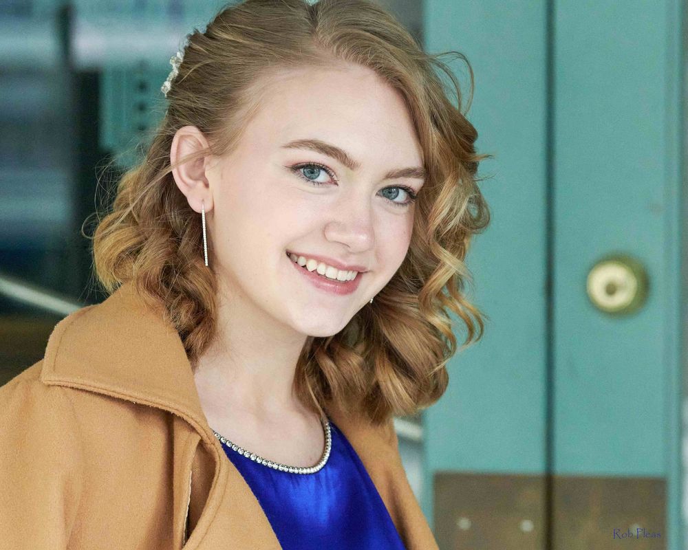 Closeup of blonde high school senior female wearing tan jacket at Liberty Theatre in Puyallup, WA