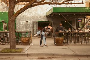 Panoramic view of an outdoor urban park with benches, trees and people relaxing in Chicago's West Garfield Park area.