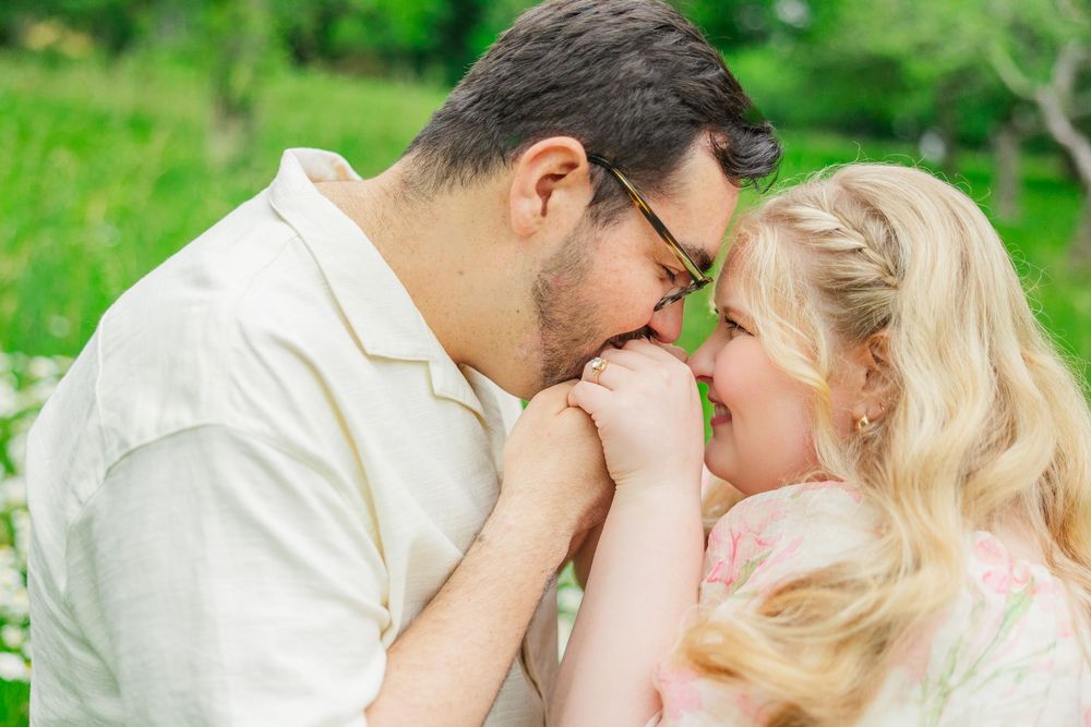 An intimate romantic moment captured between a couple against a blurred green background.