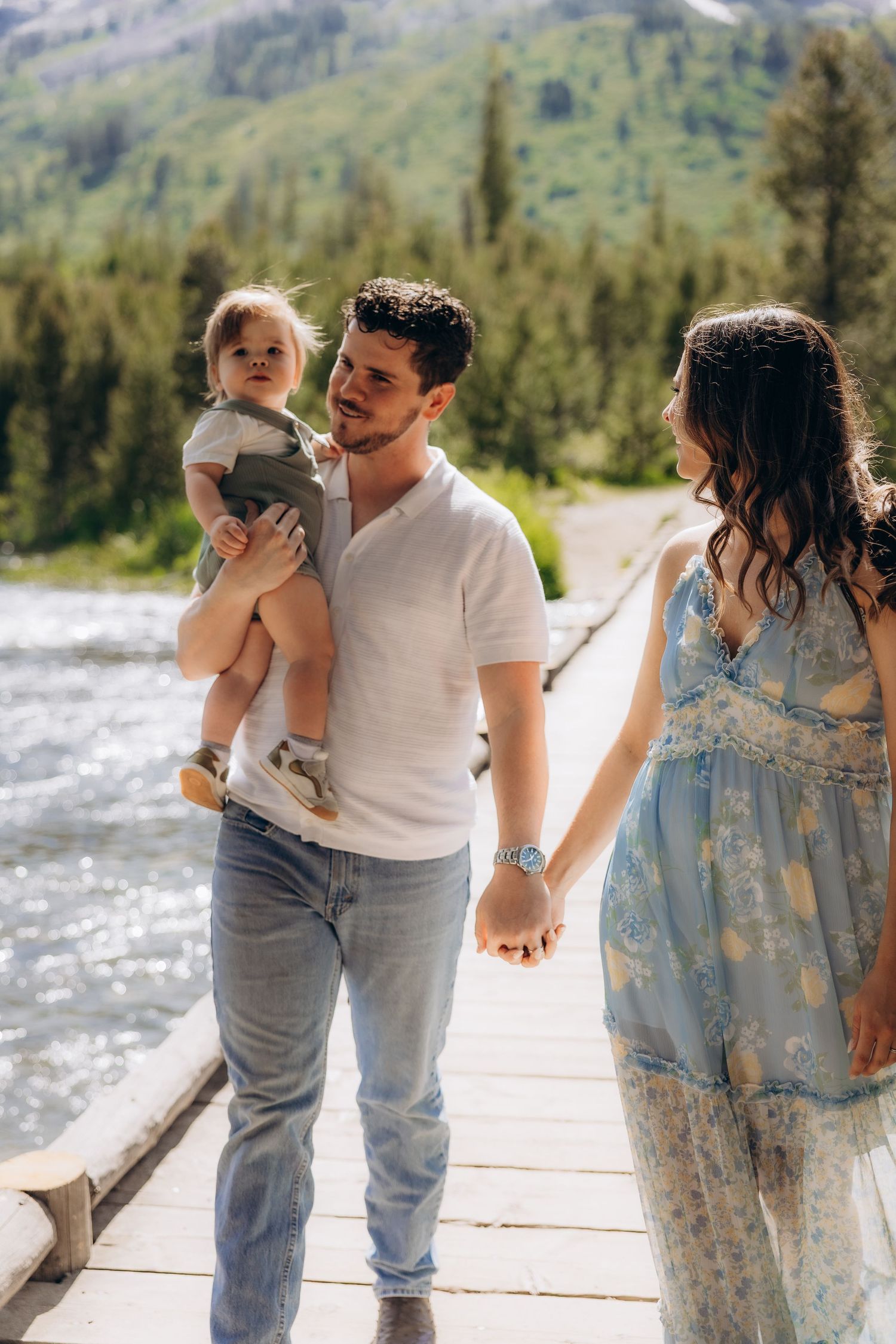 A romantic family photo session outdoors featuring tender moments between a couple and their child.