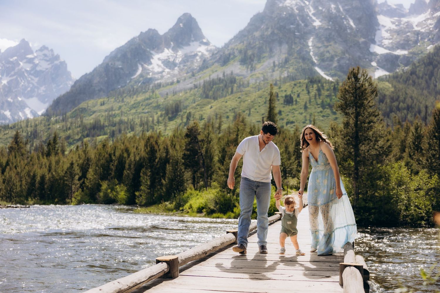 A scenic mountain landscape serves as backdrop for an intimate photo session near a lake.