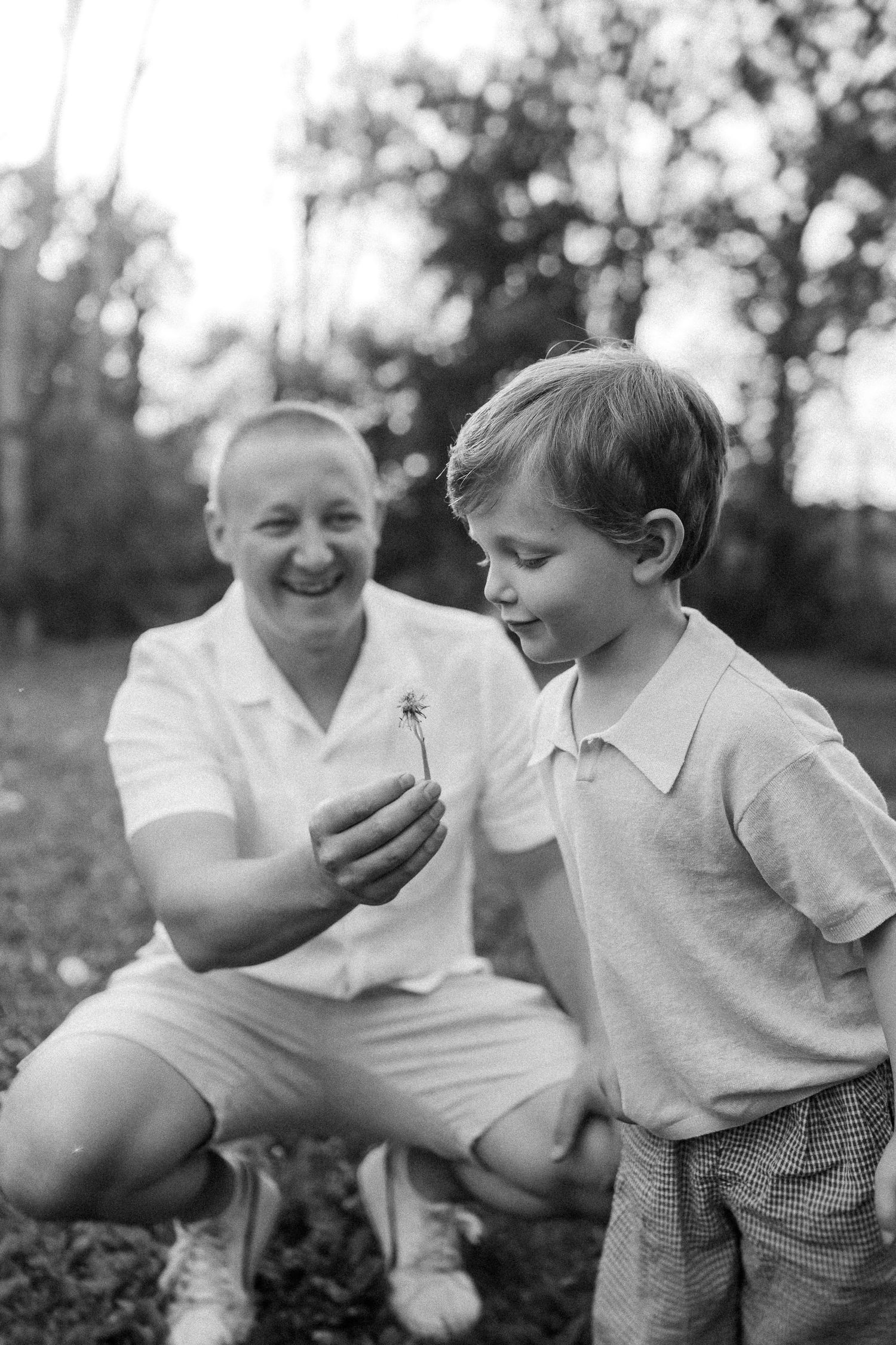 A series of black and white photographs showing a loving interaction between a parent and child outdoors.