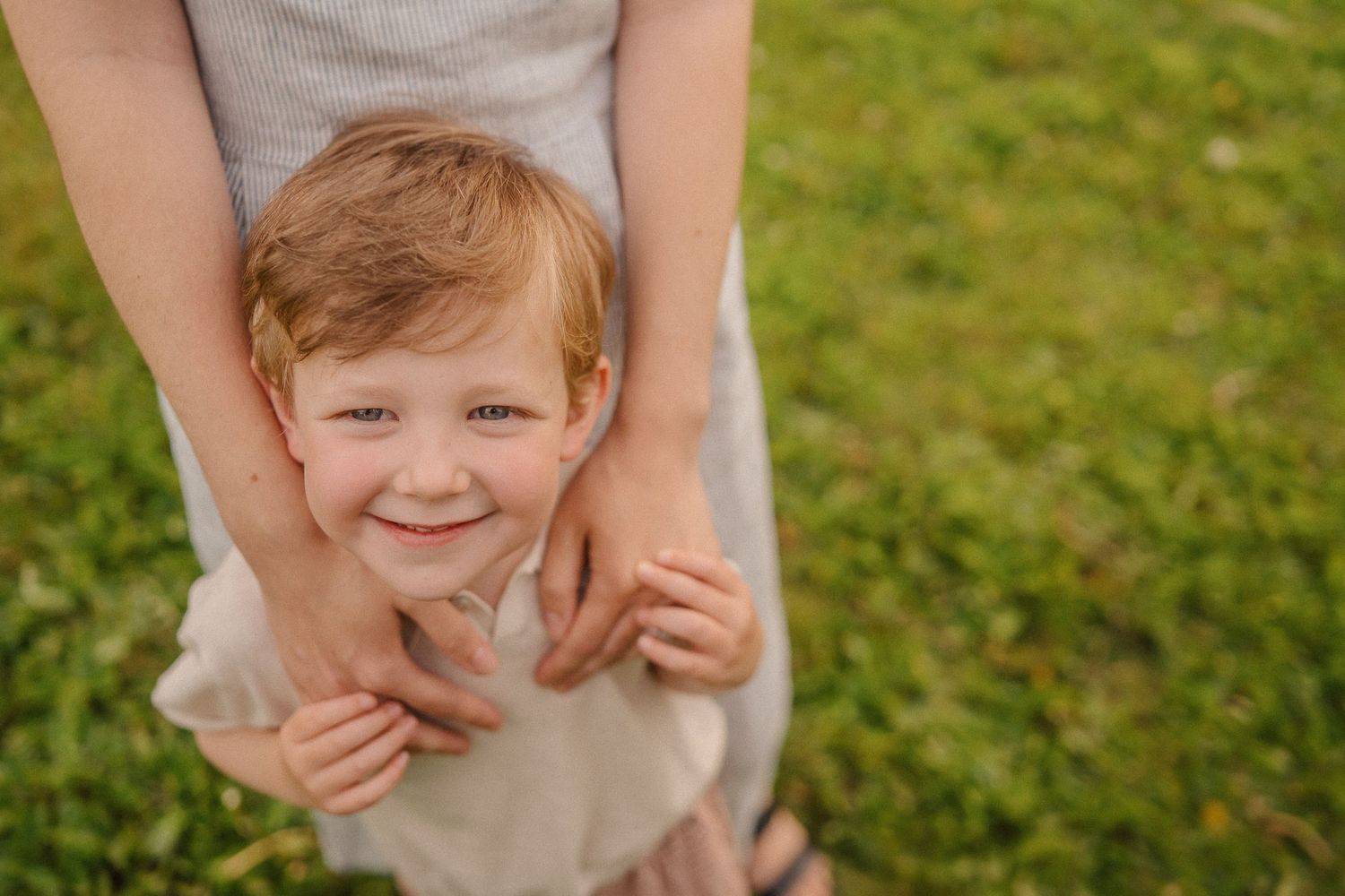 A playful moment captured in a garden with warm sunlight and green grass in the background.
