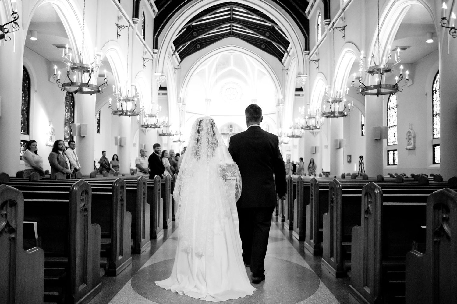 Black and white panoramic view of a traditional church ceremony with gothic architecture.