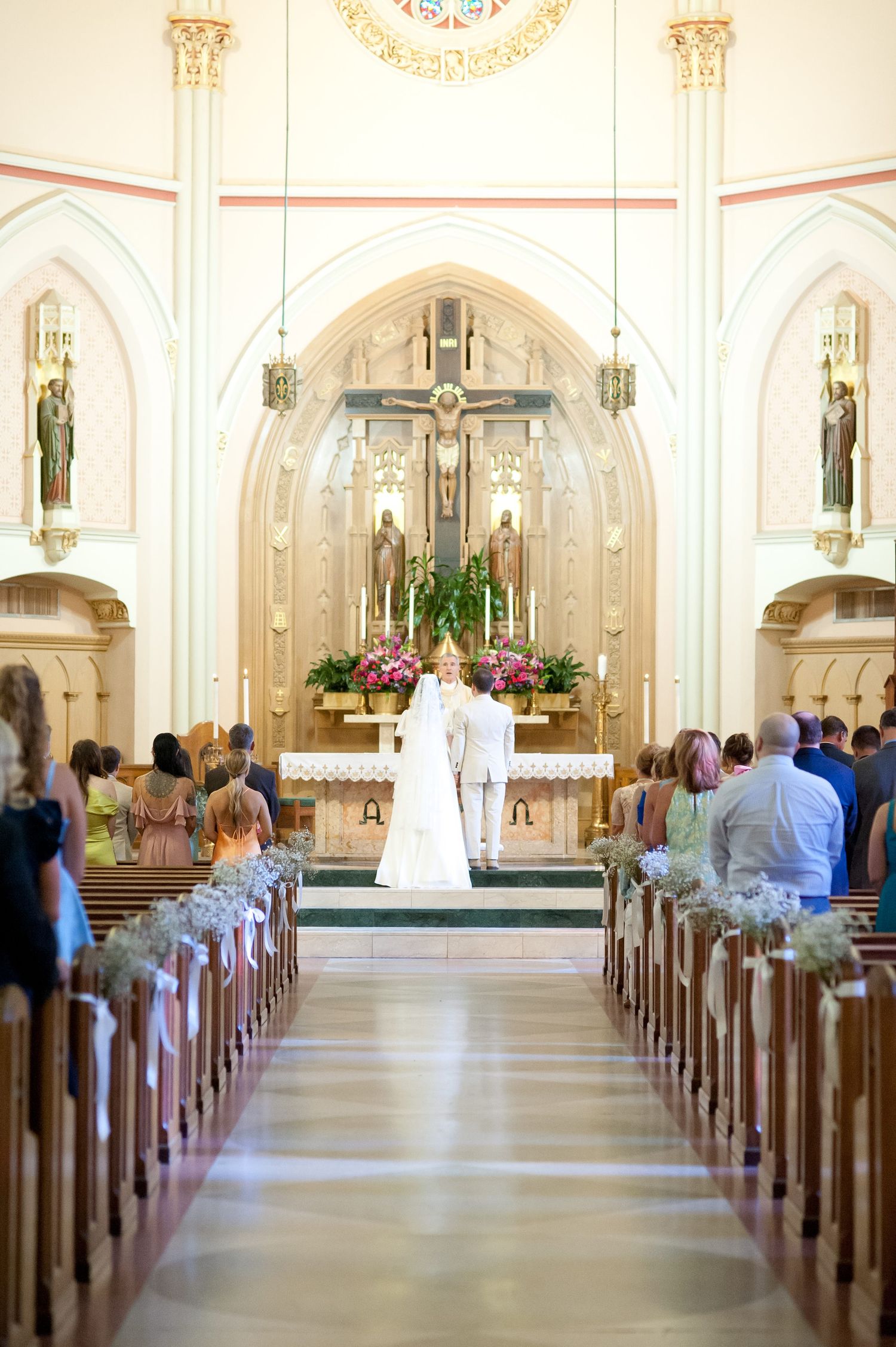 Traditional church sanctuary with vaulted ceilings and ornate details during wedding ceremony.