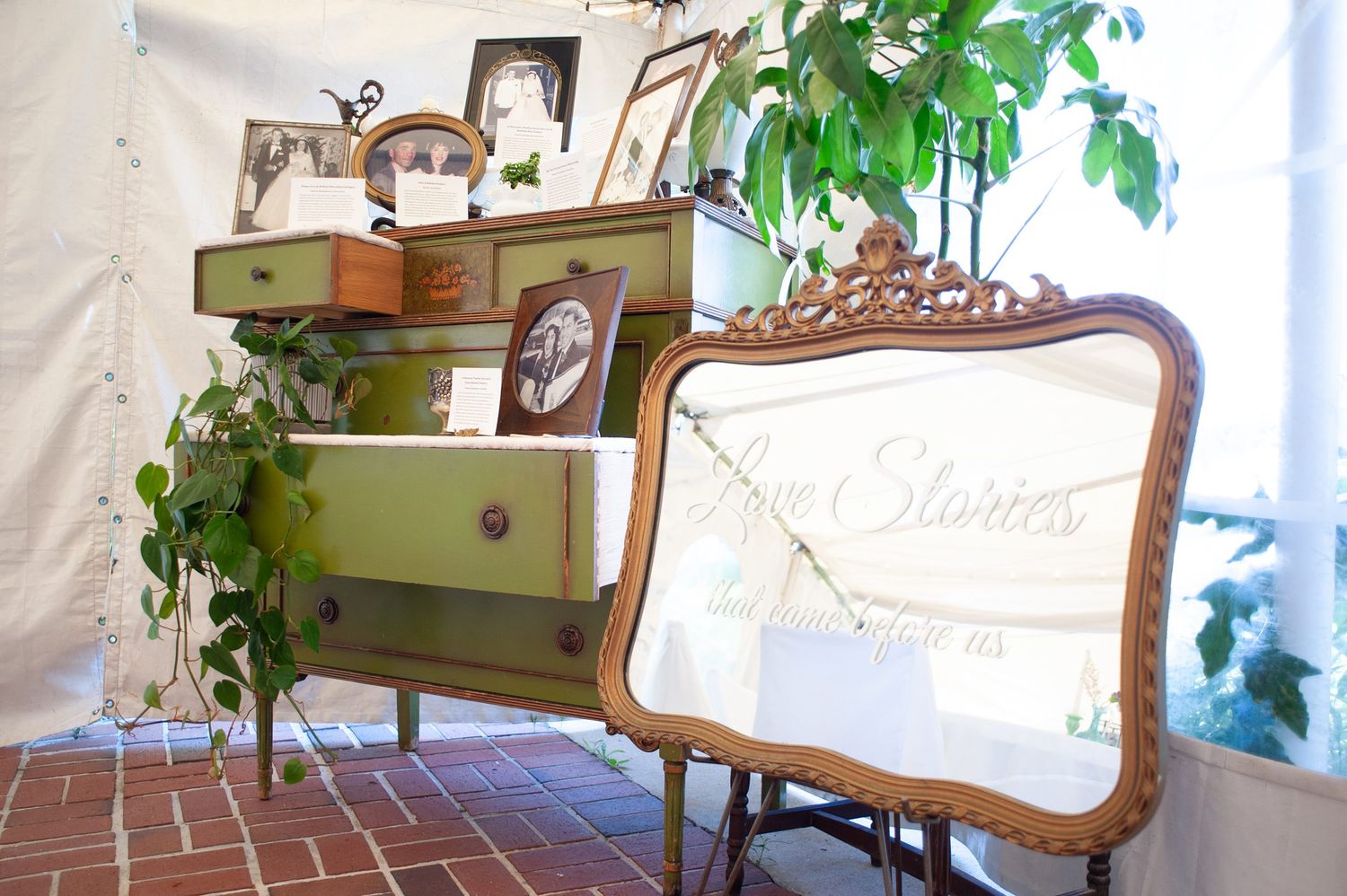 Elegant vintage furniture and decor pieces arranged in a bright sunlit room with green plants.