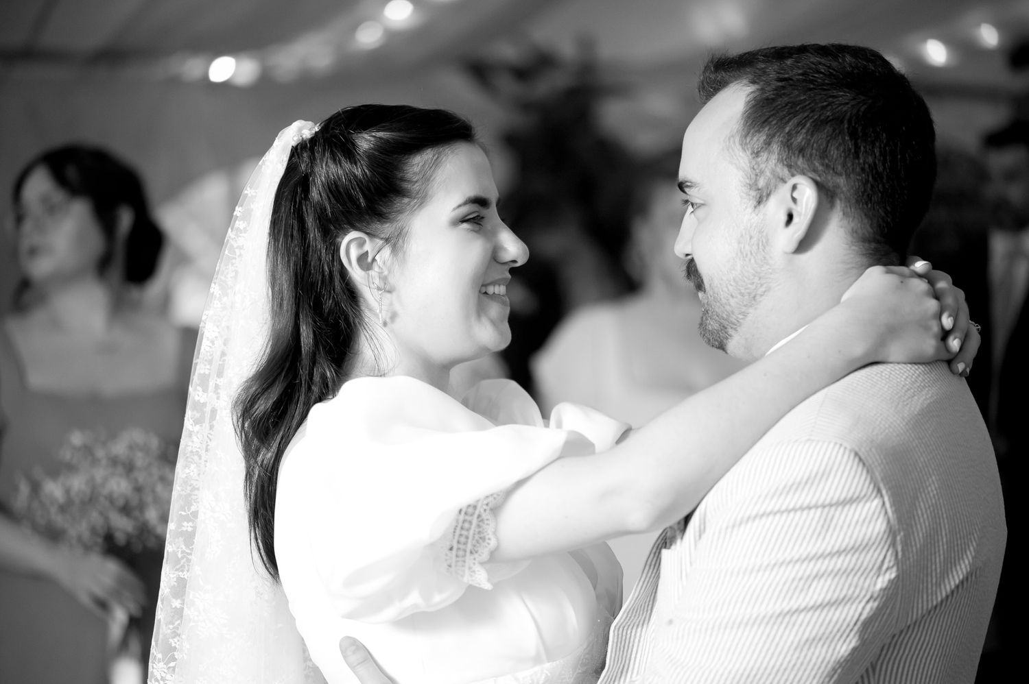 Romantic dance sequence captured in black and white under twinkling lights.