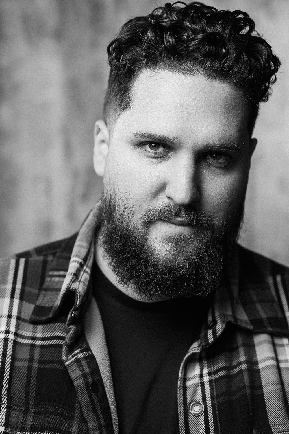 Black and white portrait series showing a bearded man in plaid flannel shirt against blurred background.