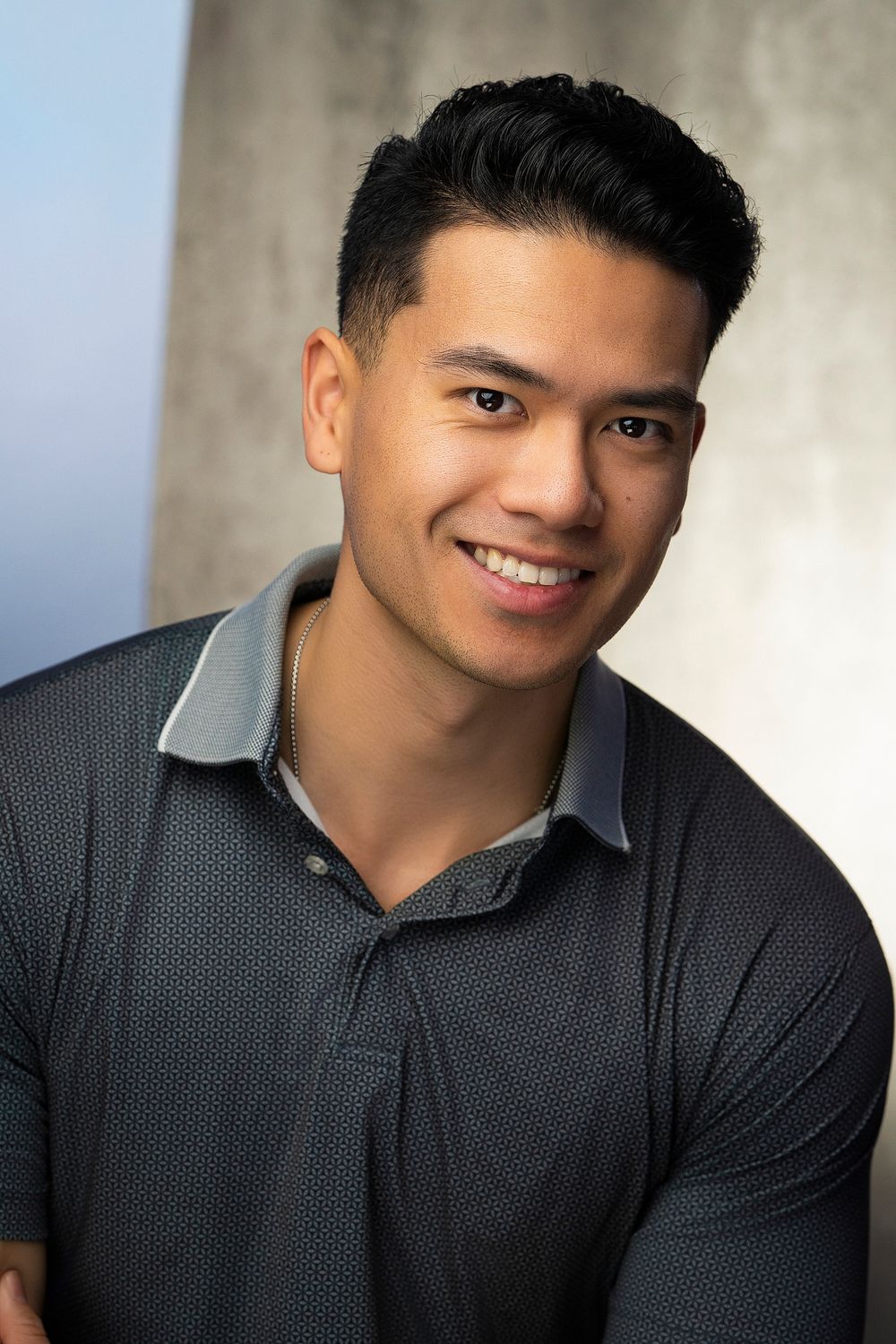 Professional headshot portrait series of a person wearing a dark polo shirt against a light background.