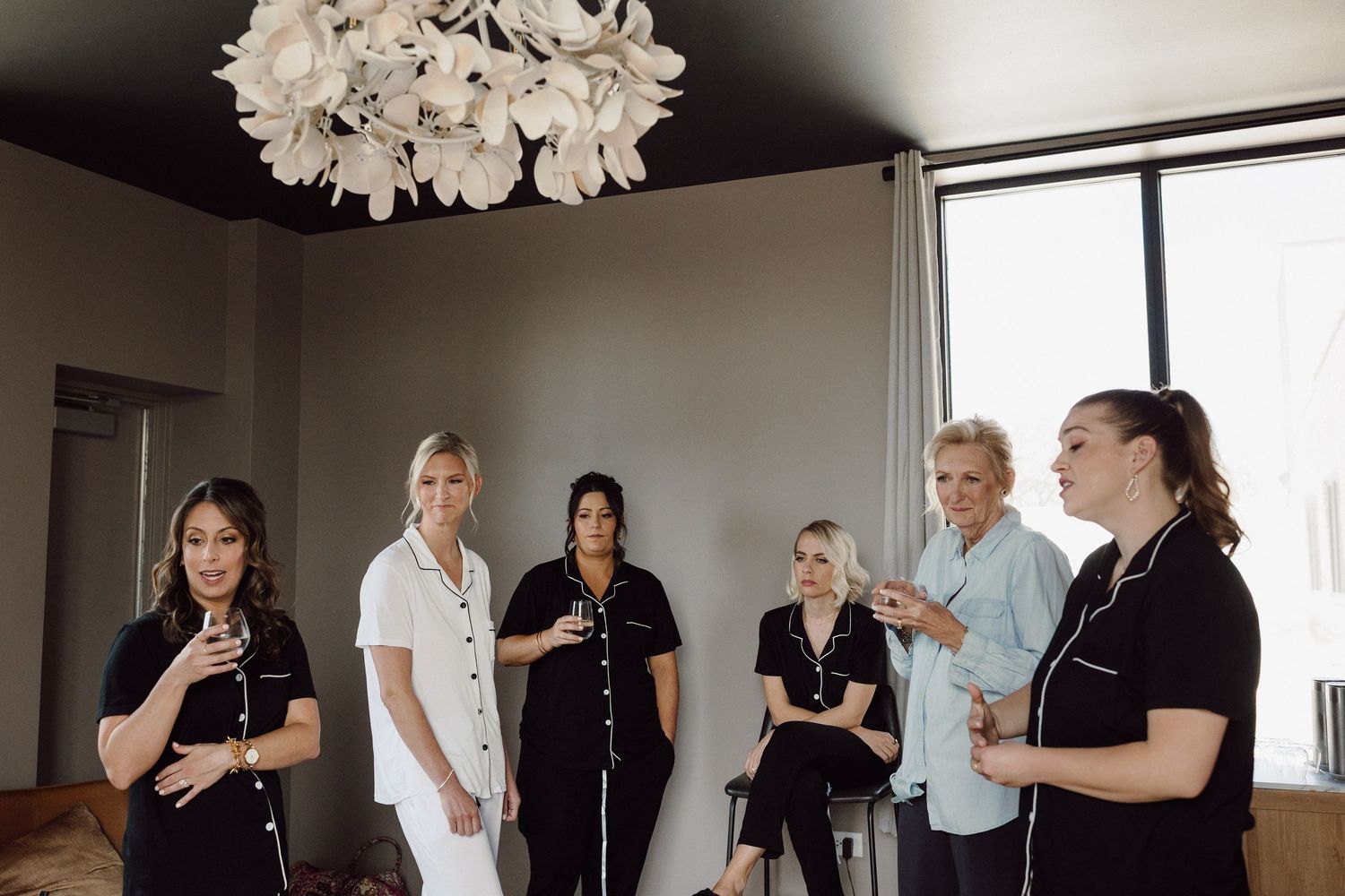 Wedding party getting ready in a bright room with white decor.