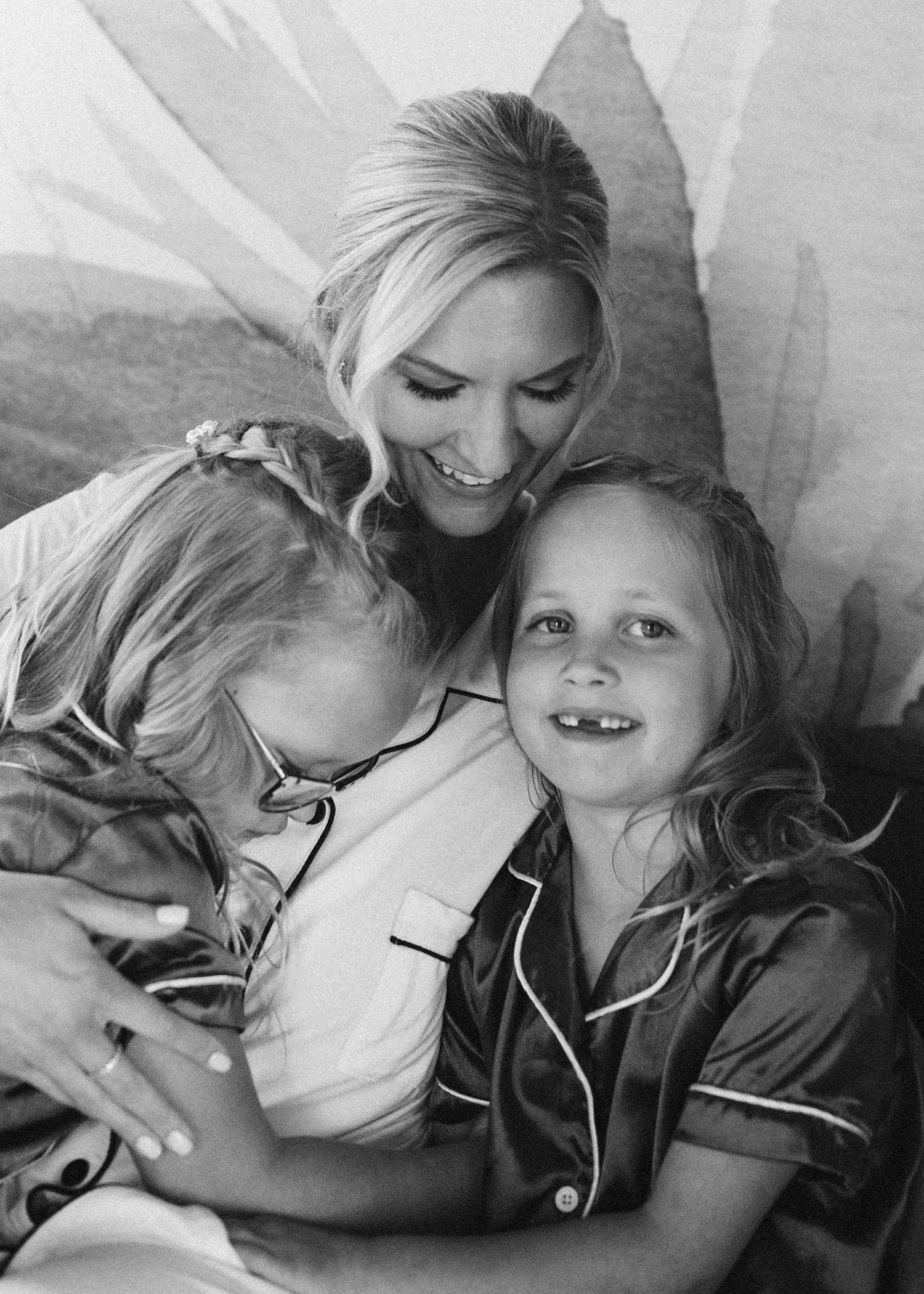 Black and white photo of family members in matching sleepwear sharing intimate moments.