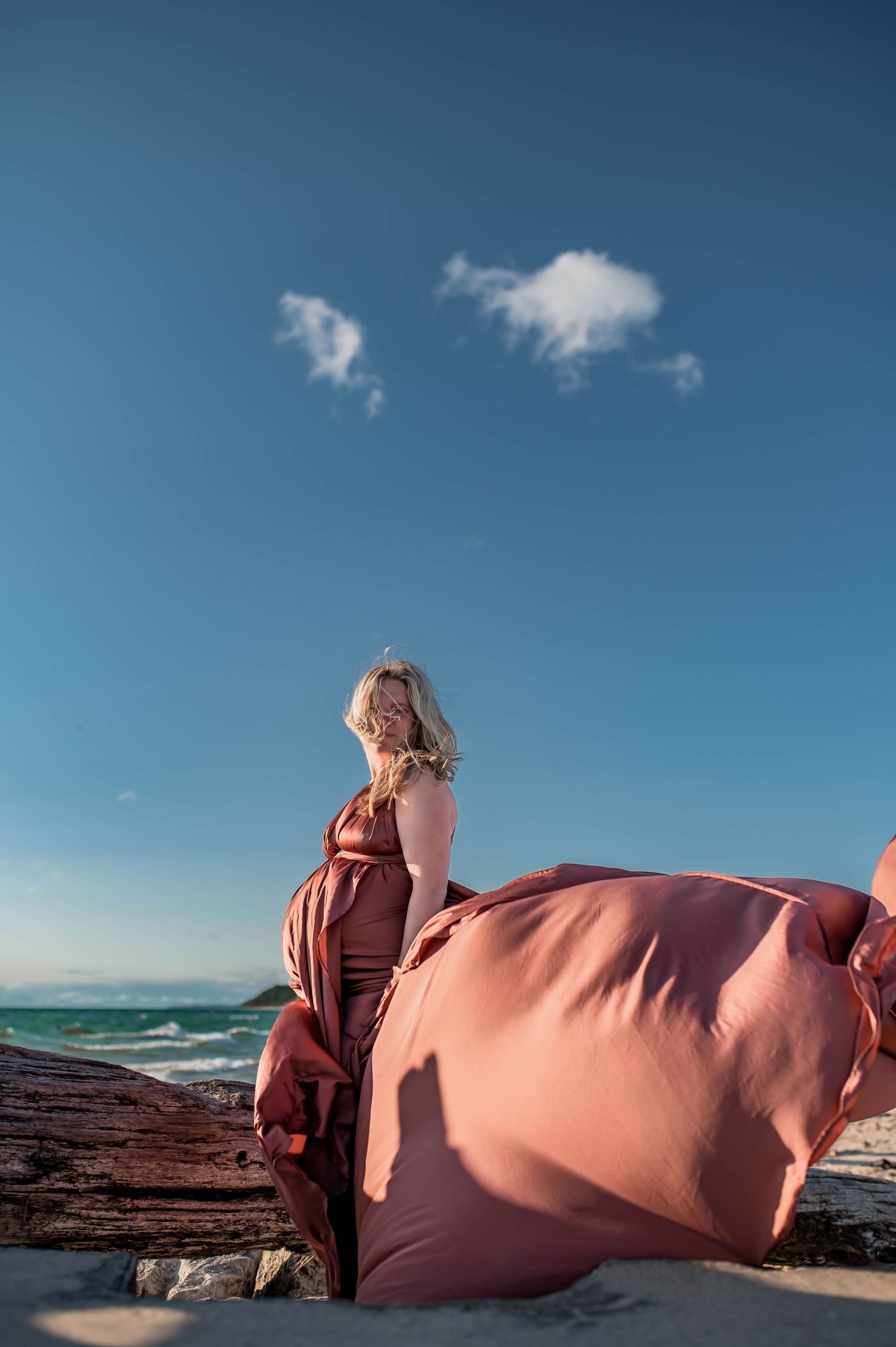 Four sequential photos show a pink beanbag being moved and positioned against a rocky coastal backdrop with blue sky and ocean.