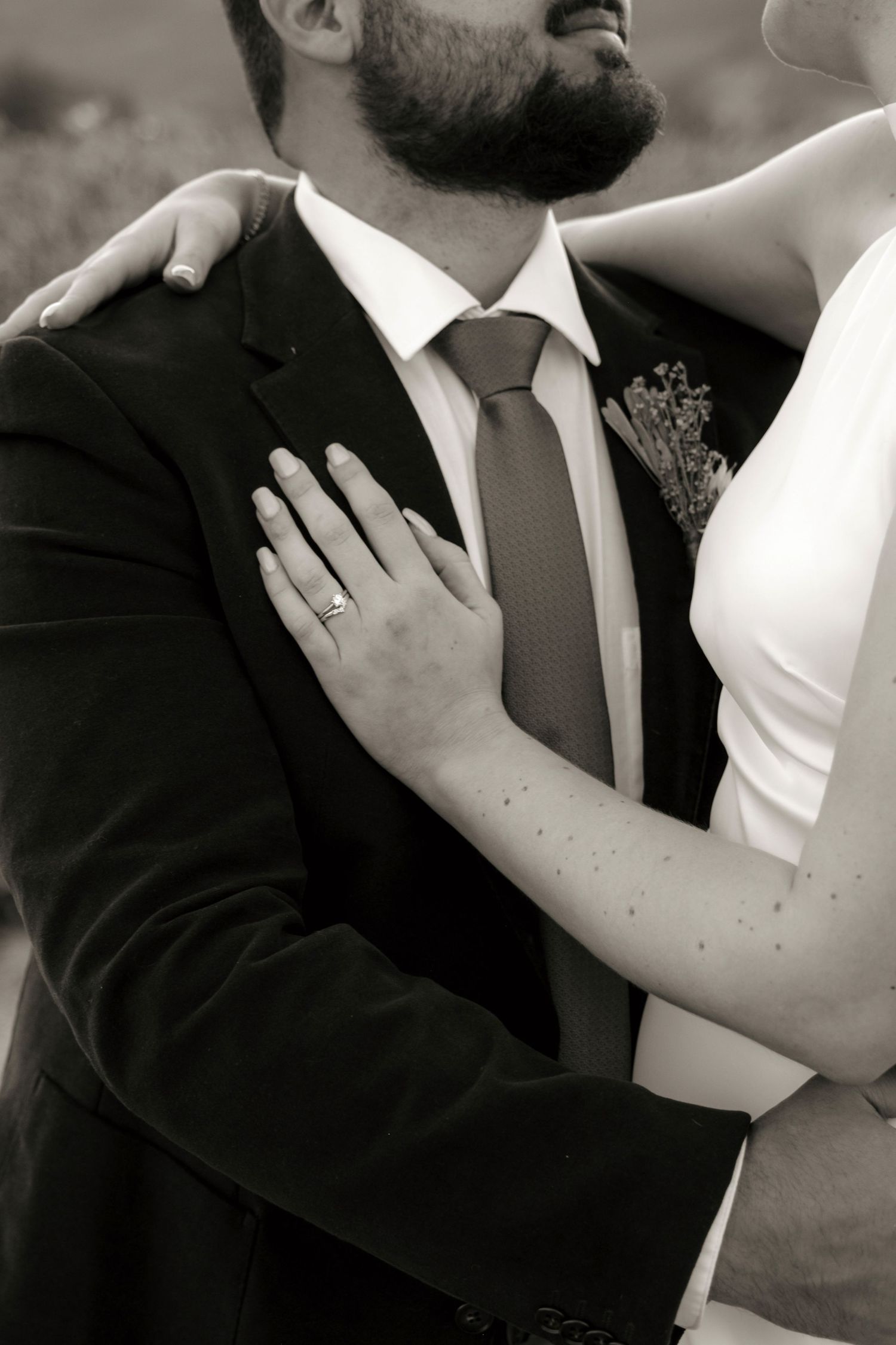 Close-up black and white romantic wedding photo showing tender moments between newlyweds sharing intimate embraces.