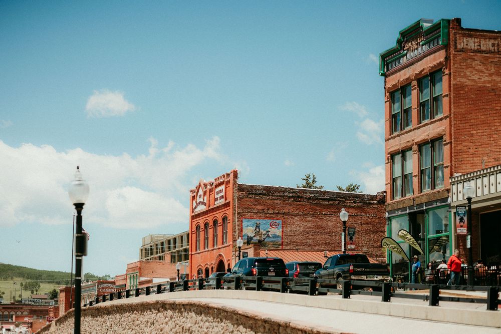 A panoramic collage of vintage brick buildings showing historic small-town storefronts along a main street.