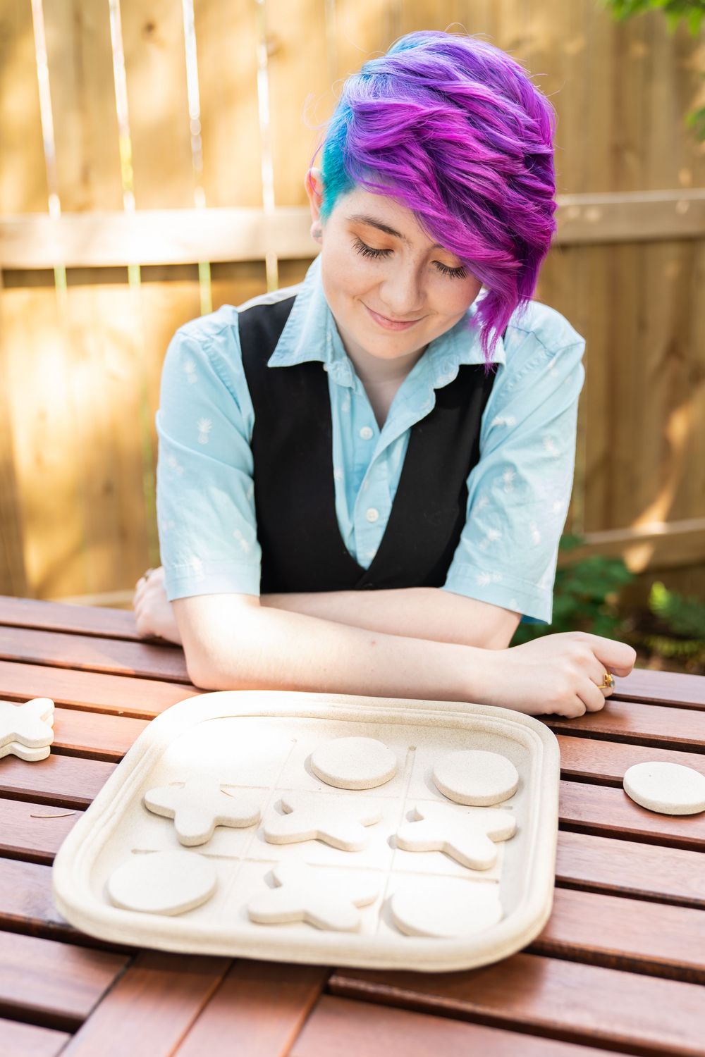 Senior portrait of a purple haired girl playing tick tack tow