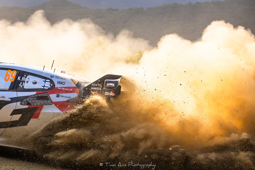Rally cars kick up clouds of dust as they race across a desert landscape during an off-road competition.