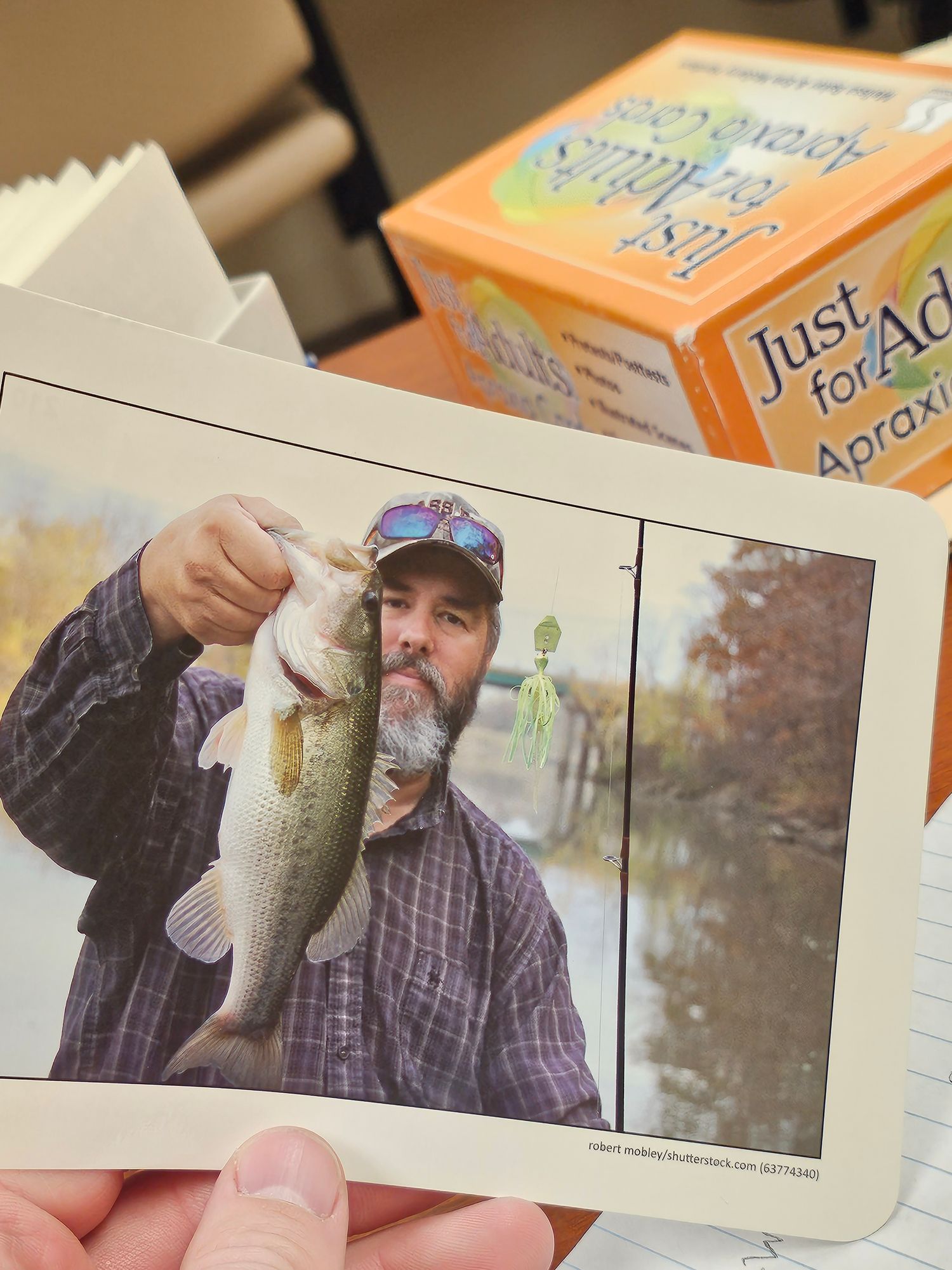 Four similar photos showing someone in a plaid shirt and hat holding a fish against a wooded outdoor background.