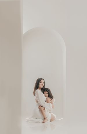 Minimalist portrait in white archway showcasing tender family connection.