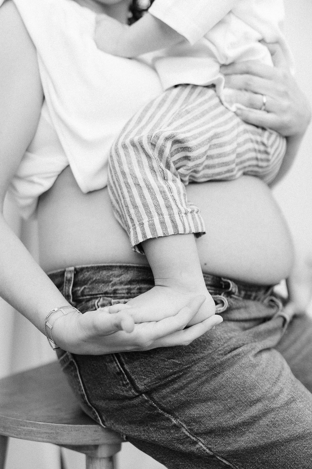 A black and white photo series shows a side view of hands gently resting on a denim-clad hip and waist area.
