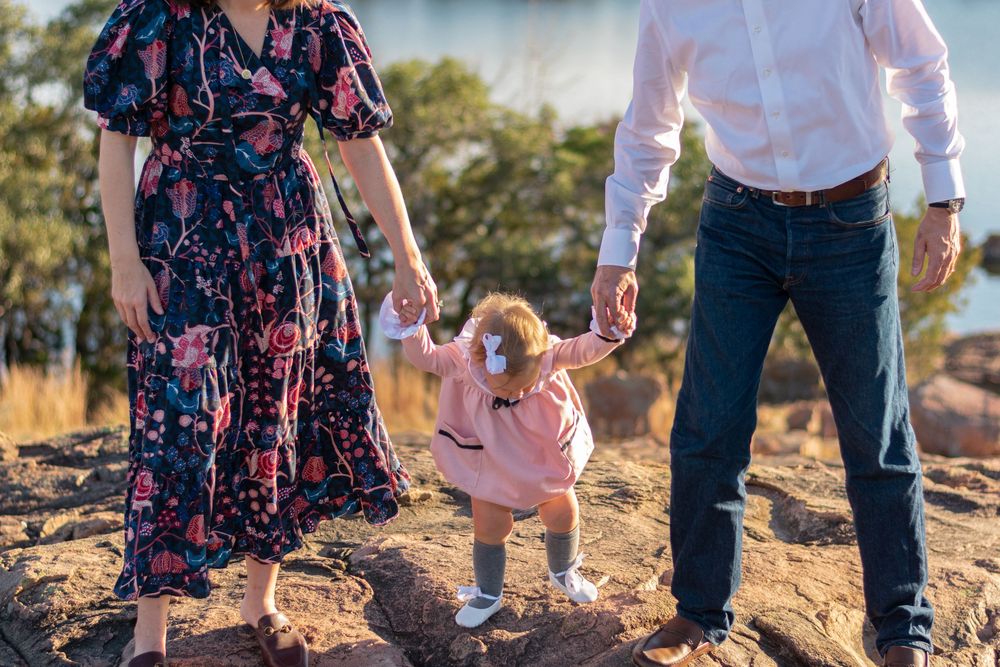 Family walking together on dirt path during golden hour.