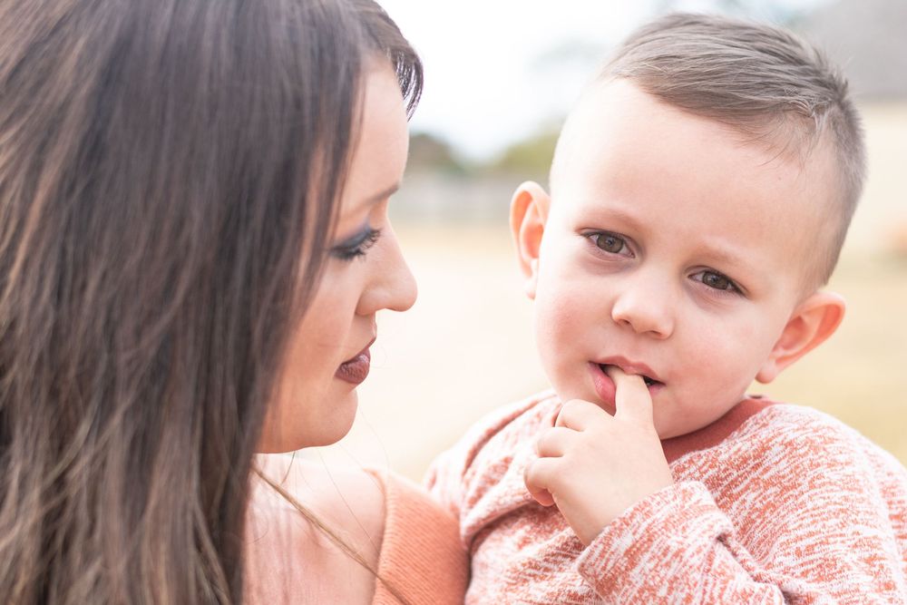 Mother and child sharing tender moments together outdoors.