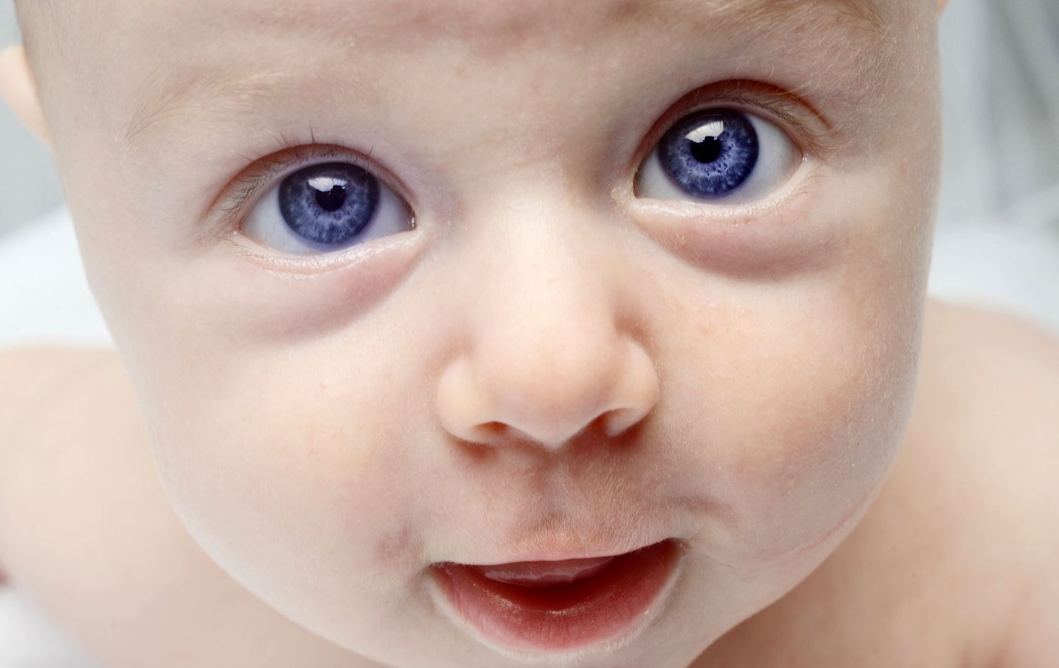 Close-up sequence of bright blue eyes and sweet expressions of a baby.