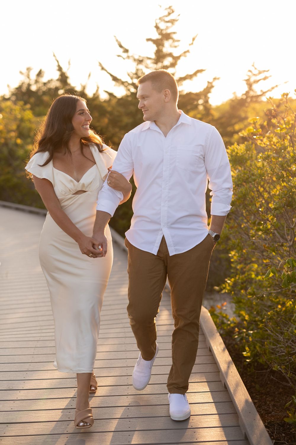 A couple walks on a boardwalk at sunset, their movement captured in a series of romantic candid photos.
