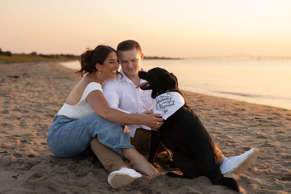 Family enjoys tender moments together while relaxing on a scenic beach at sunset.