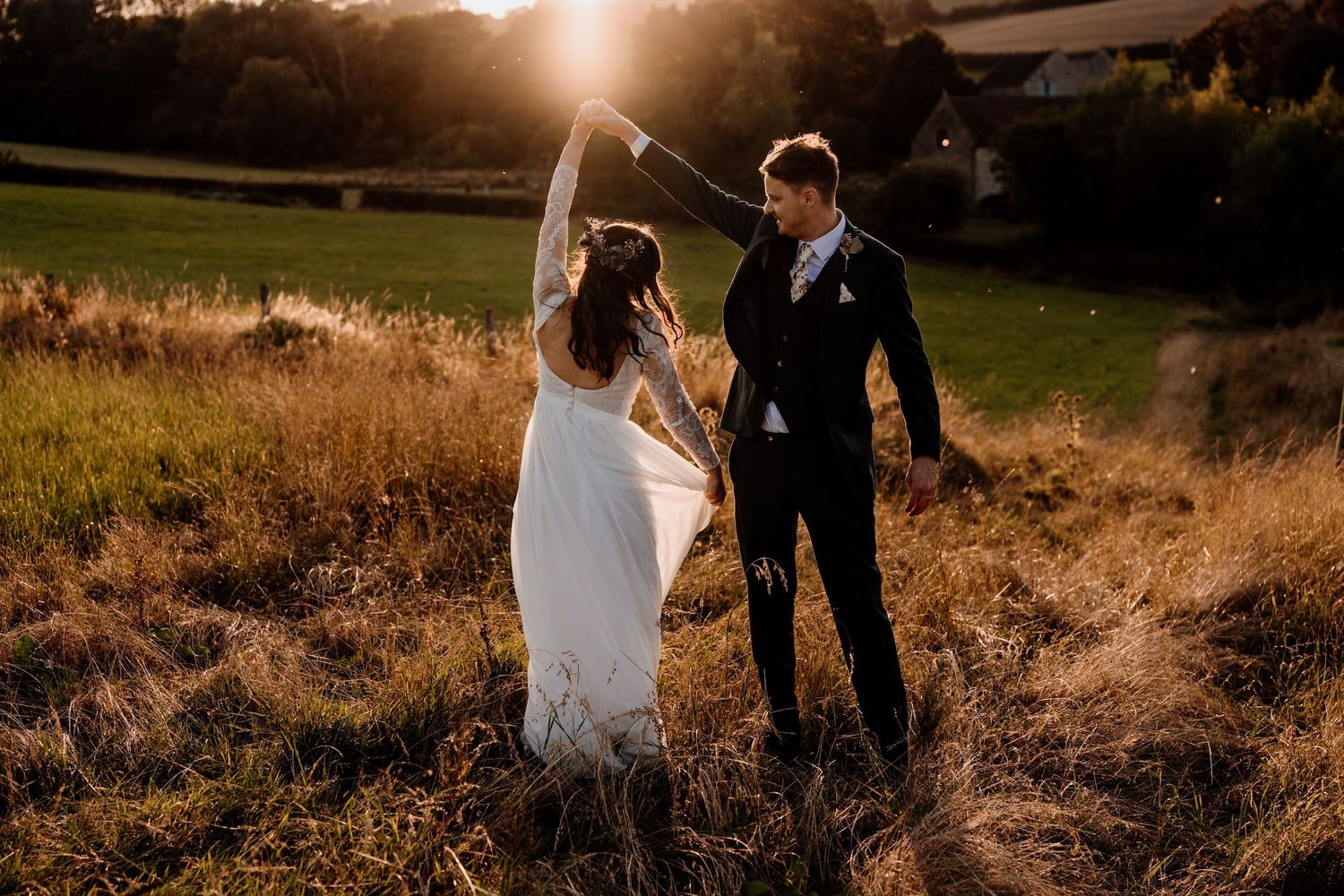 Silhouettes of a romantic couple during golden hour in a field.