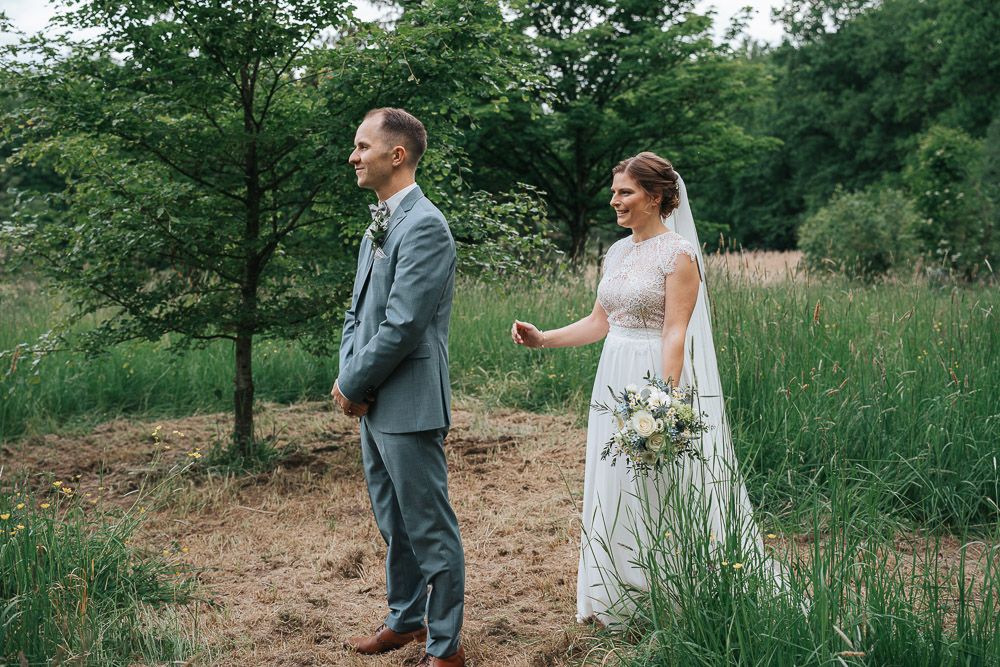 Couple sharing romantic moments during their wedding photoshoot in a secluded forest clearing.