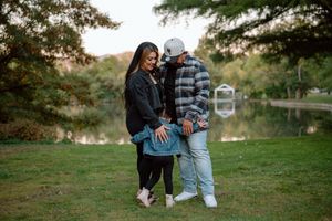 Couple in casual denim and plaid outfits enjoying an intimate moment together outdoors during golden hour.