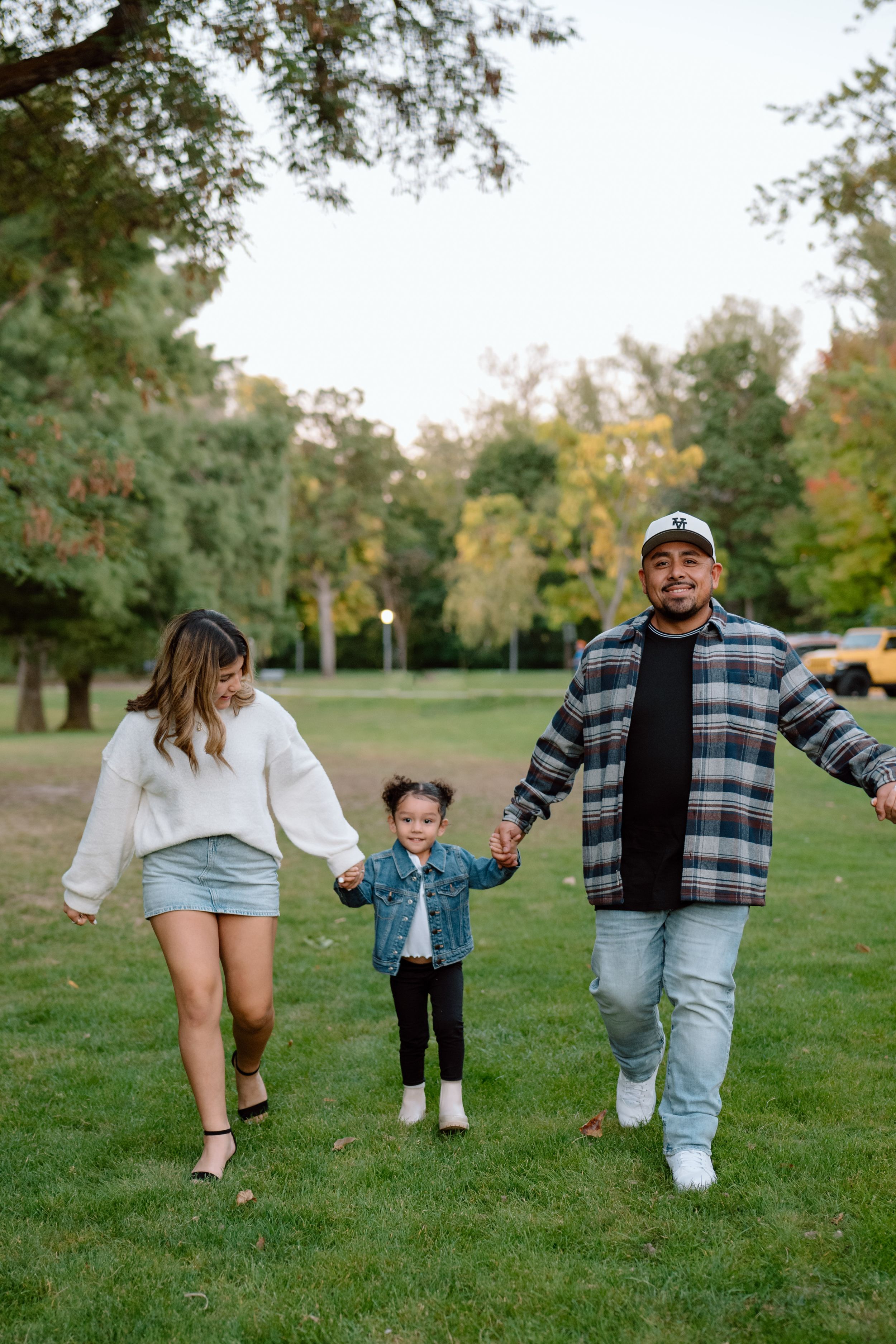 Playful family moment captured in a series of connected photos showing people walking and having fun in a grassy park.