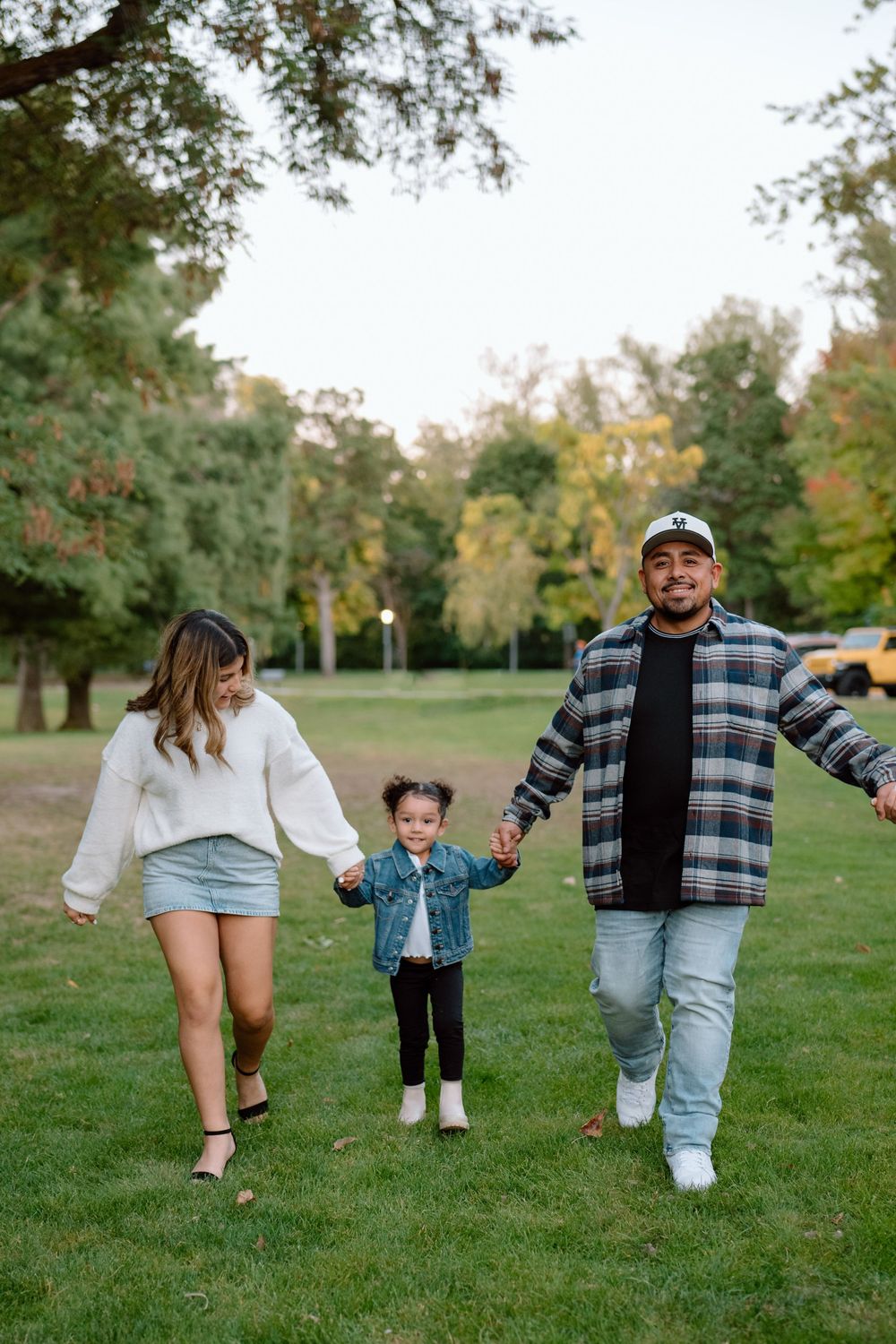 Playful family moment captured in a series of connected photos showing people walking and having fun in a grassy park.