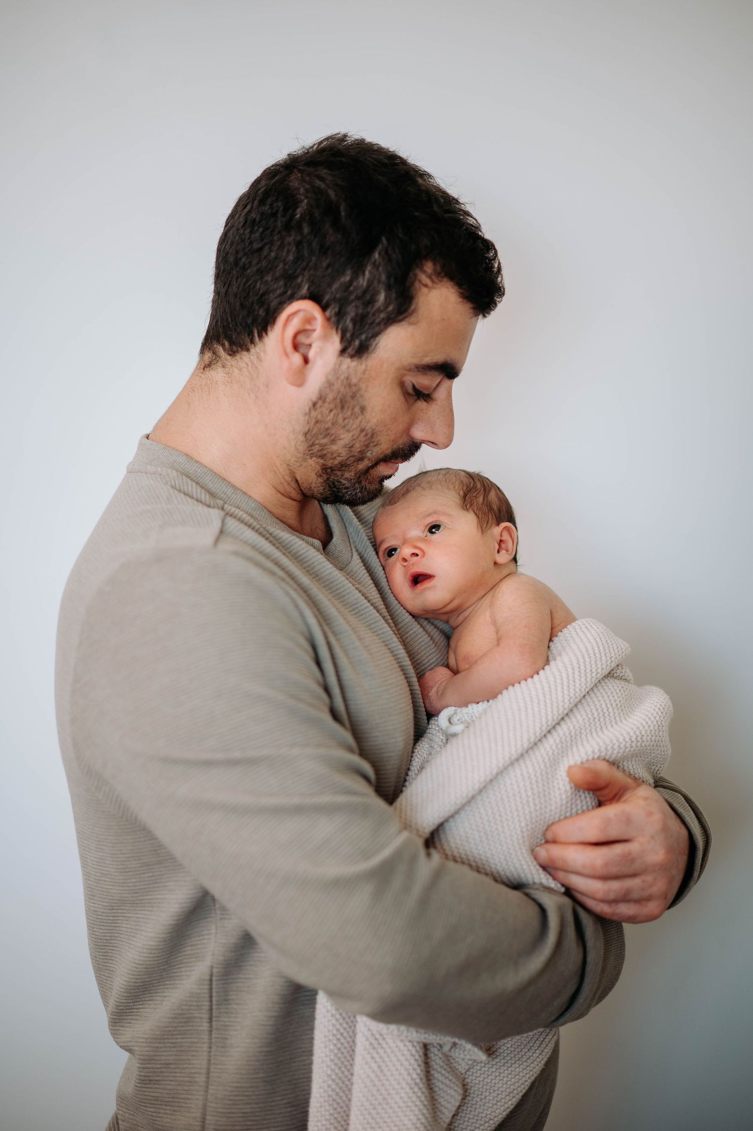 A tender moment between parent and child as they embrace in a series of connected photos against a light background.