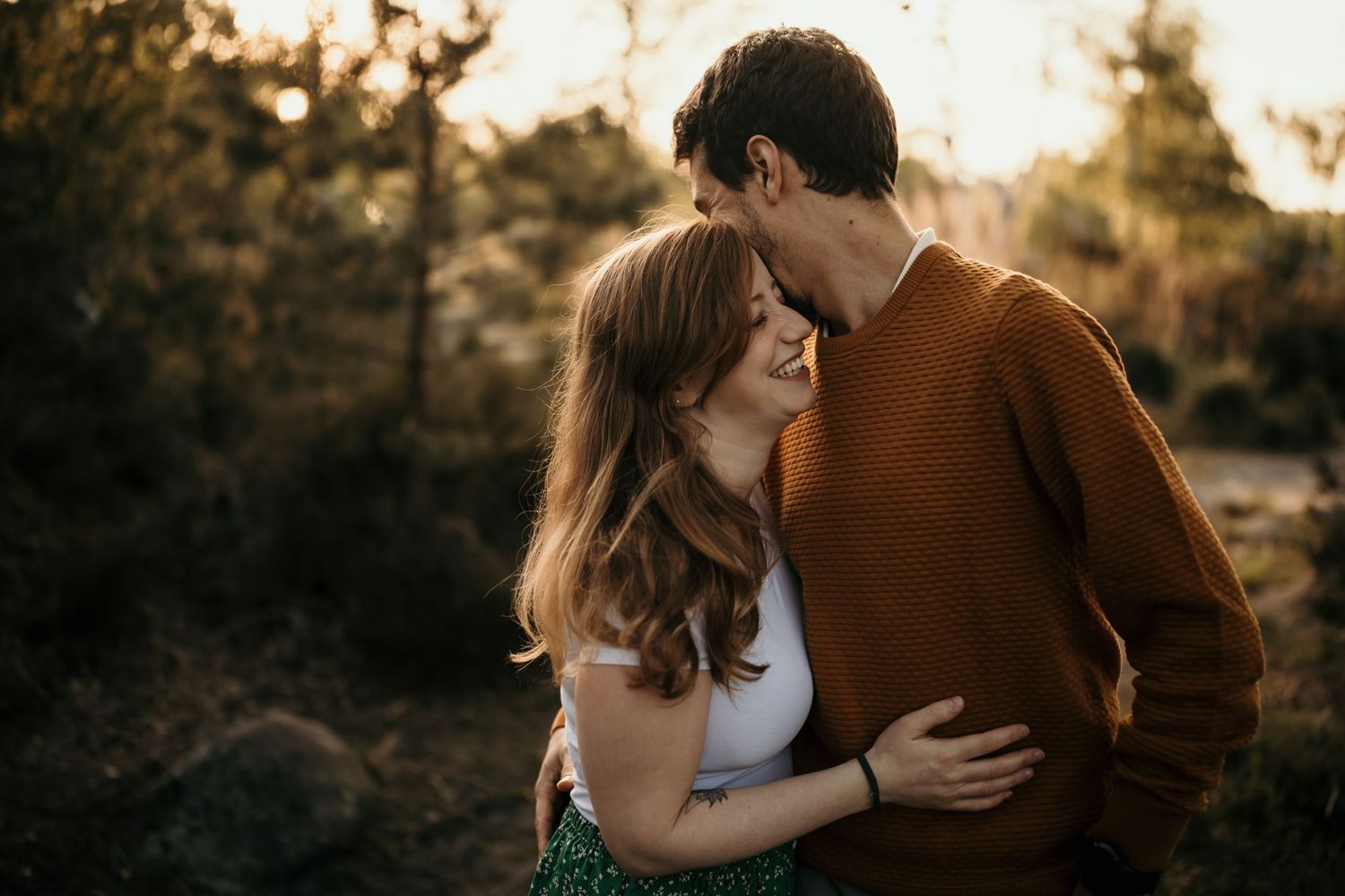 A romantic moment between partners in warm autumn light surrounded by nature.