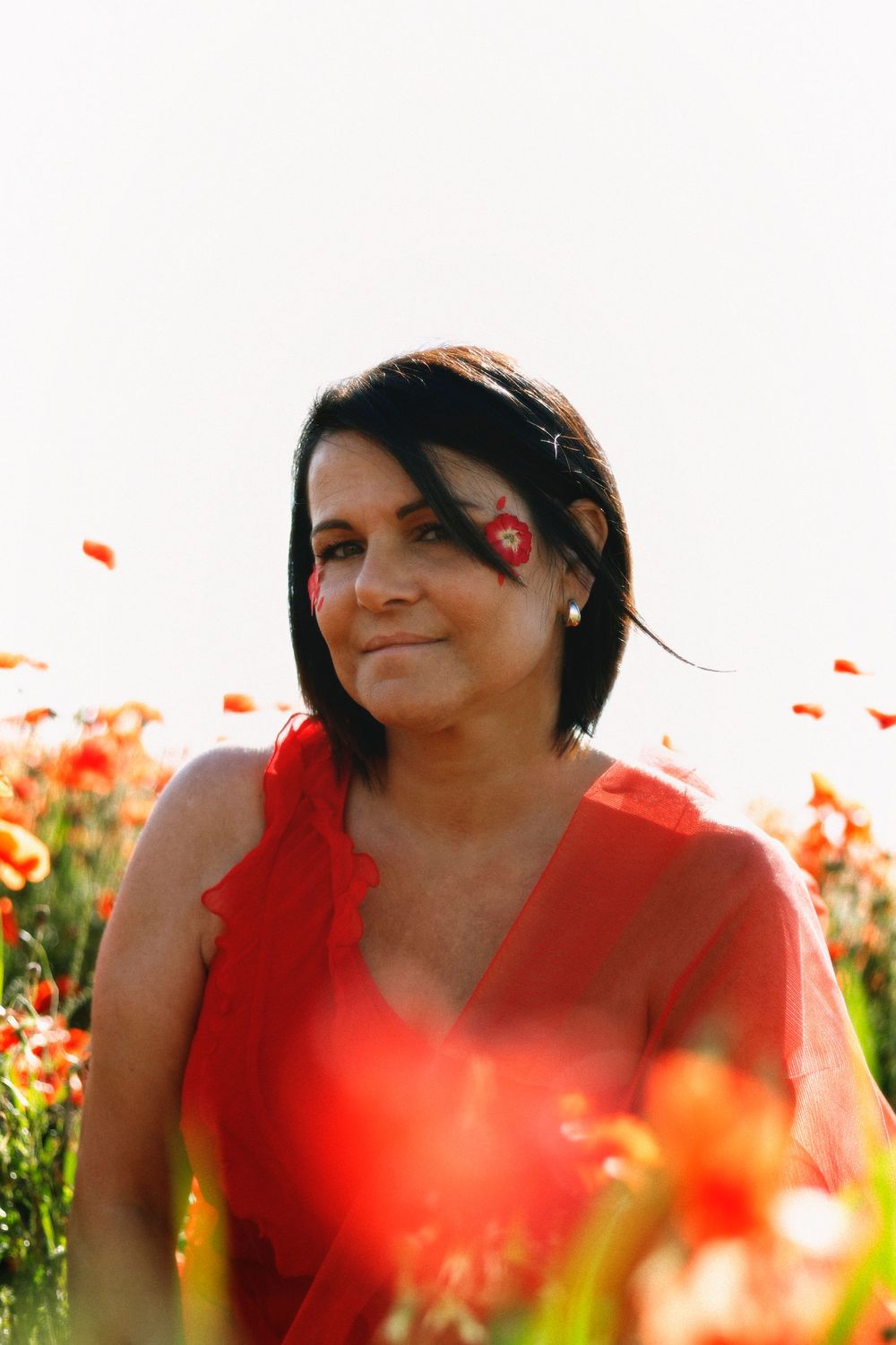Séance photo par Chaemi Studio, photographe à Montpellier. Shooting à Mauguio aux couleurs rouges au milieu des coquelicots au printemps.