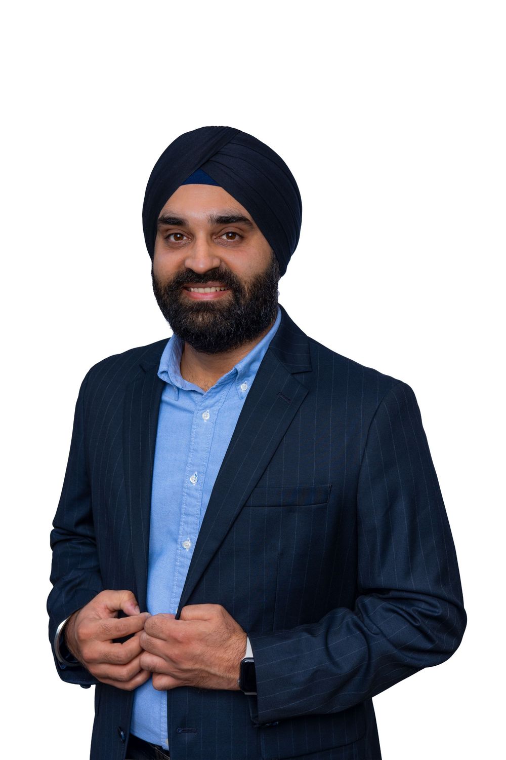 Professional business portrait of a person wearing a navy turban and suit with light blue dress shirt against white background.