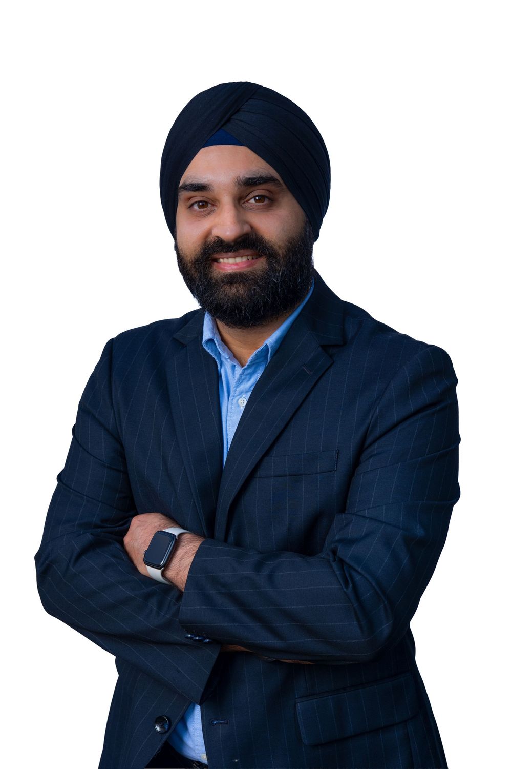 Professional business portrait of a person in a dark suit and turban against a light background with arms crossed.