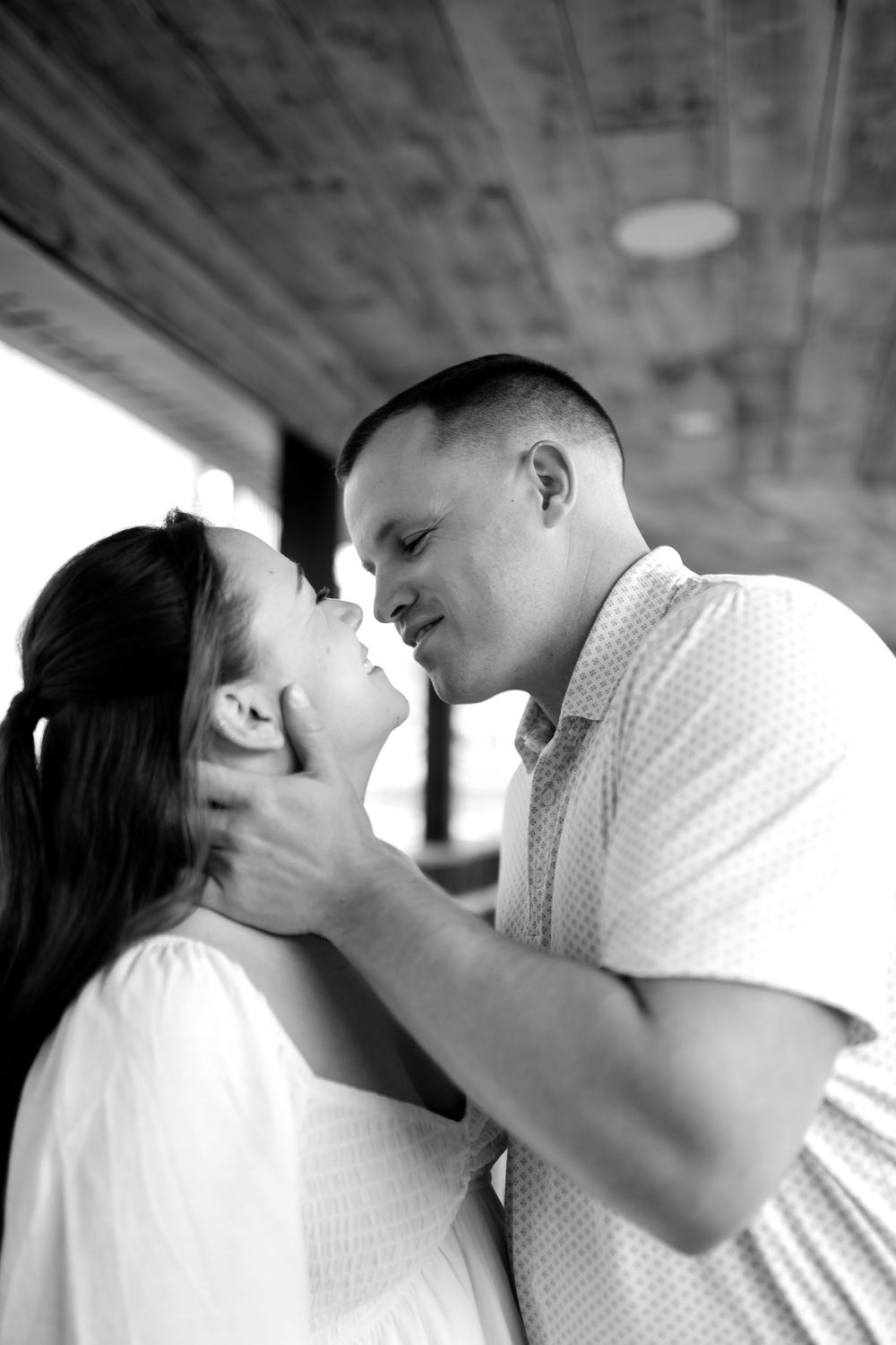 A tender black and white portrait of a romantic couple sharing an intimate moment together.
