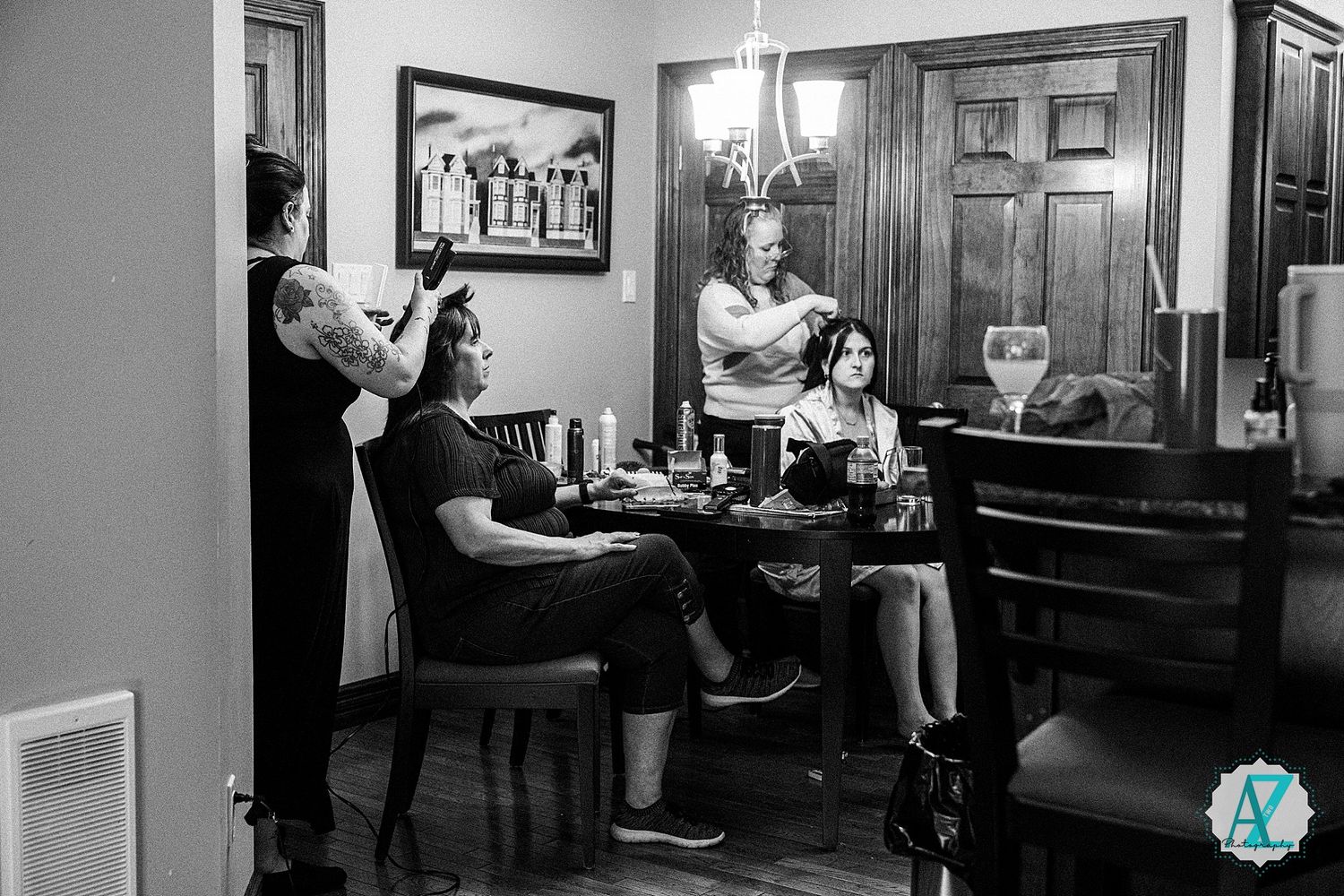 A black and white photograph shows a restaurant dining scene with patrons and wait staff in an elegant interior setting.