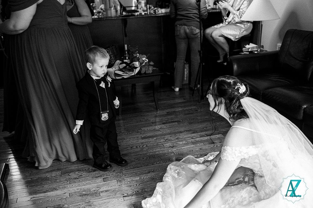 Joyful wedding guests dance together on a rustic wooden dance floor at an evening reception celebration.