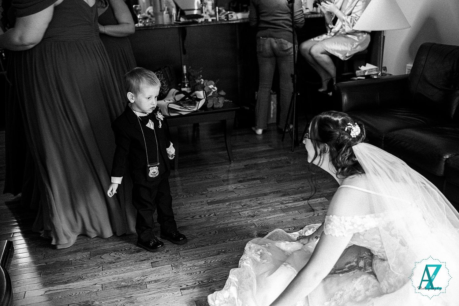 Joyful wedding guests dance together on a rustic wooden dance floor at an evening reception celebration.