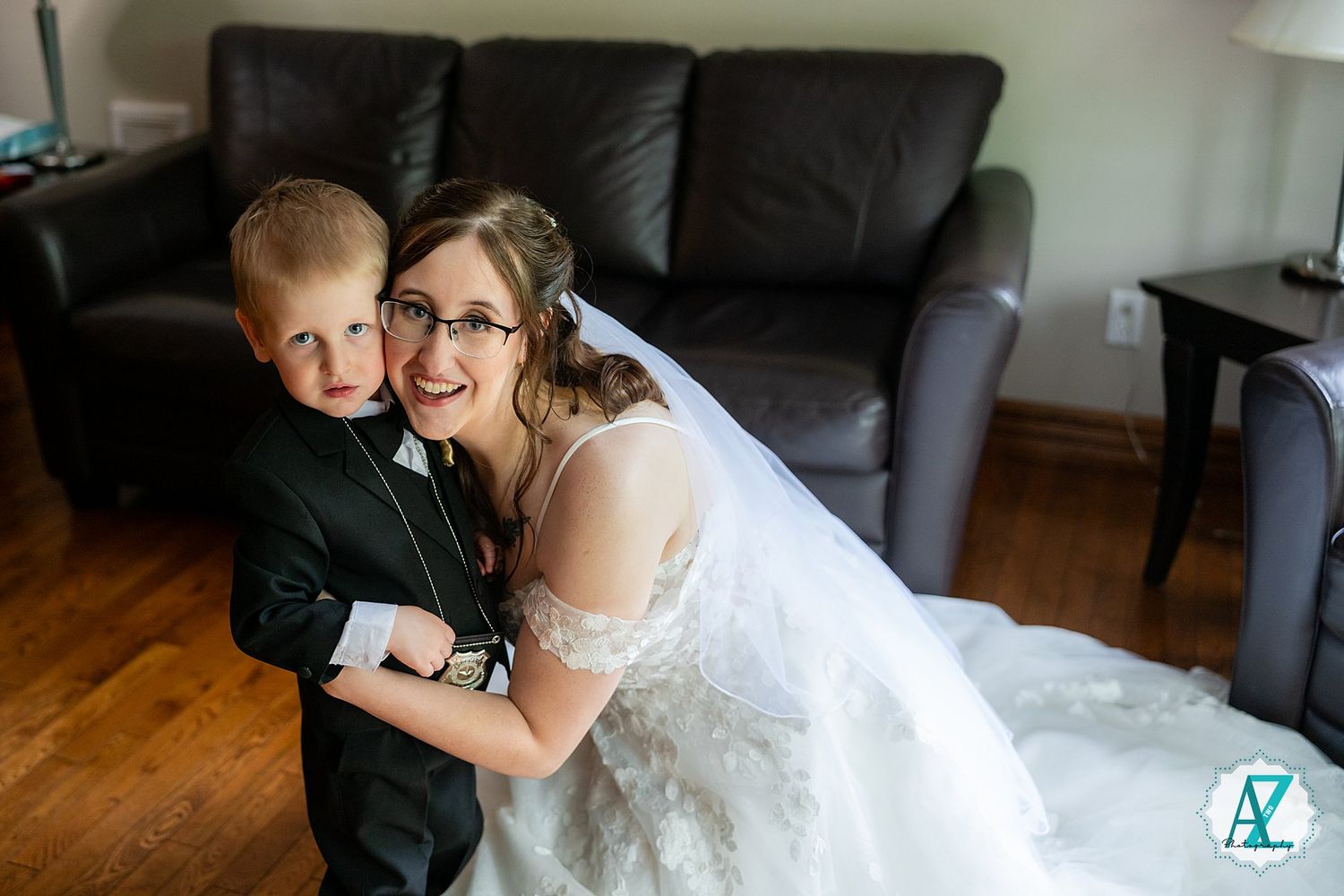 A heartwarming embrace and shared laughter between a young boy in dark clothing and a bride in a white dress.