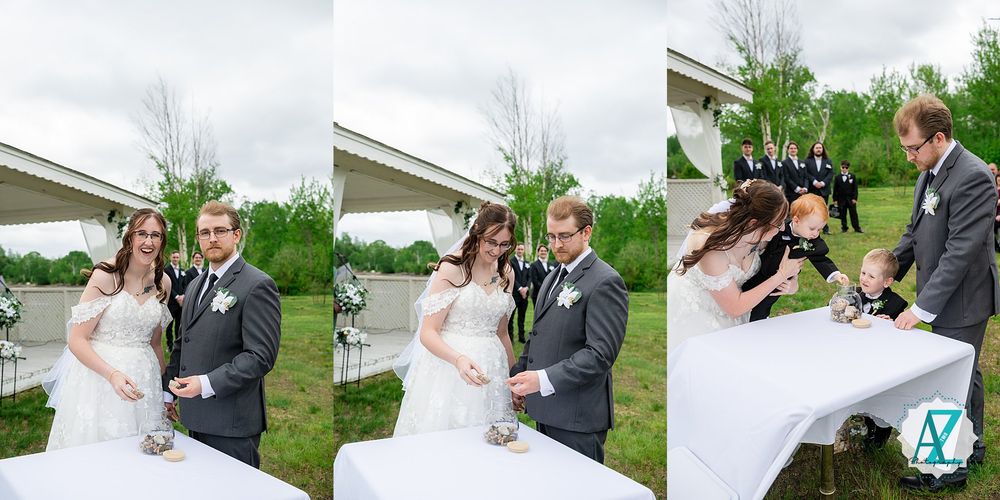 Bride and groom share a playful moment on their wedding day under cloudy skies in a lush outdoor setting.