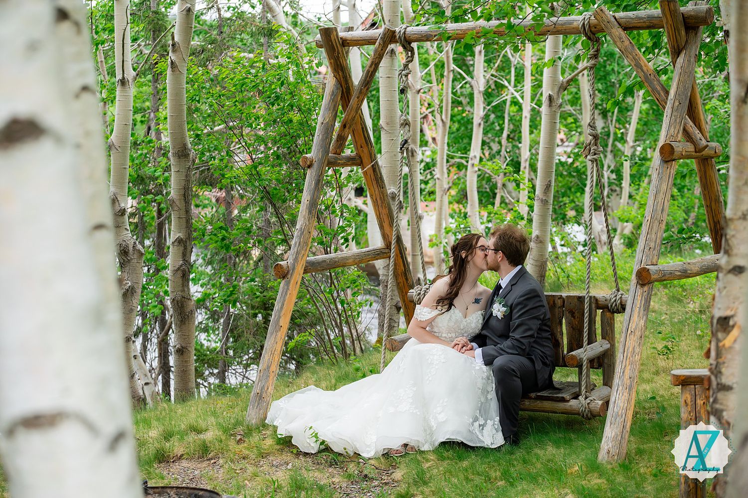 Wooden swing set surrounded by birch trees and lush greenery in a romantic outdoor setting.